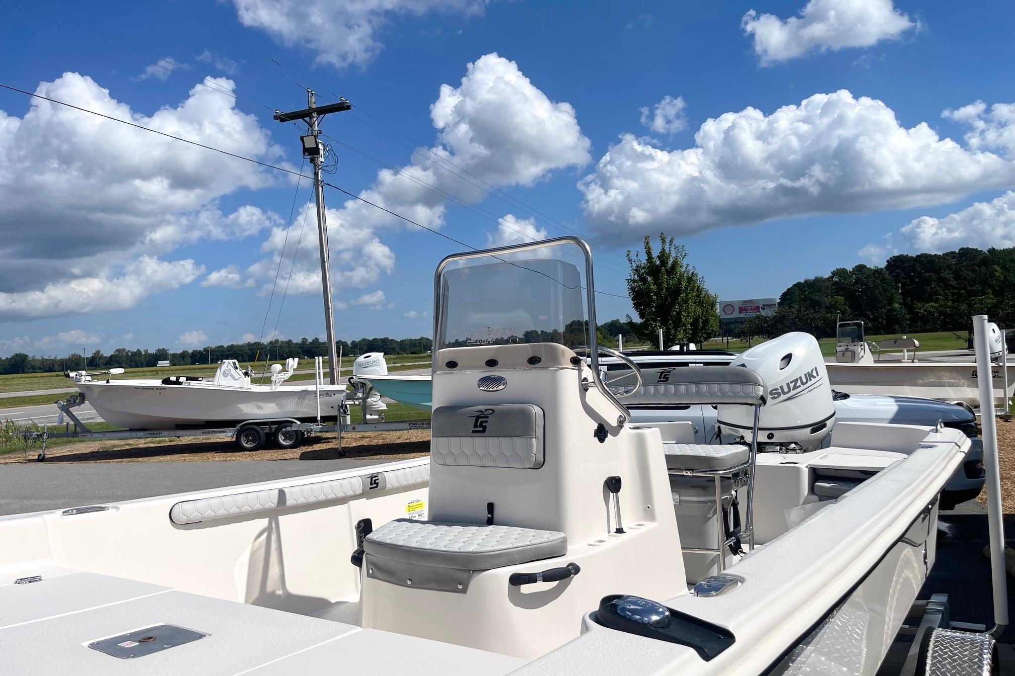 2026 Carolina Skiff 19 LS boat with Suzuki engine under a clear blue sky.