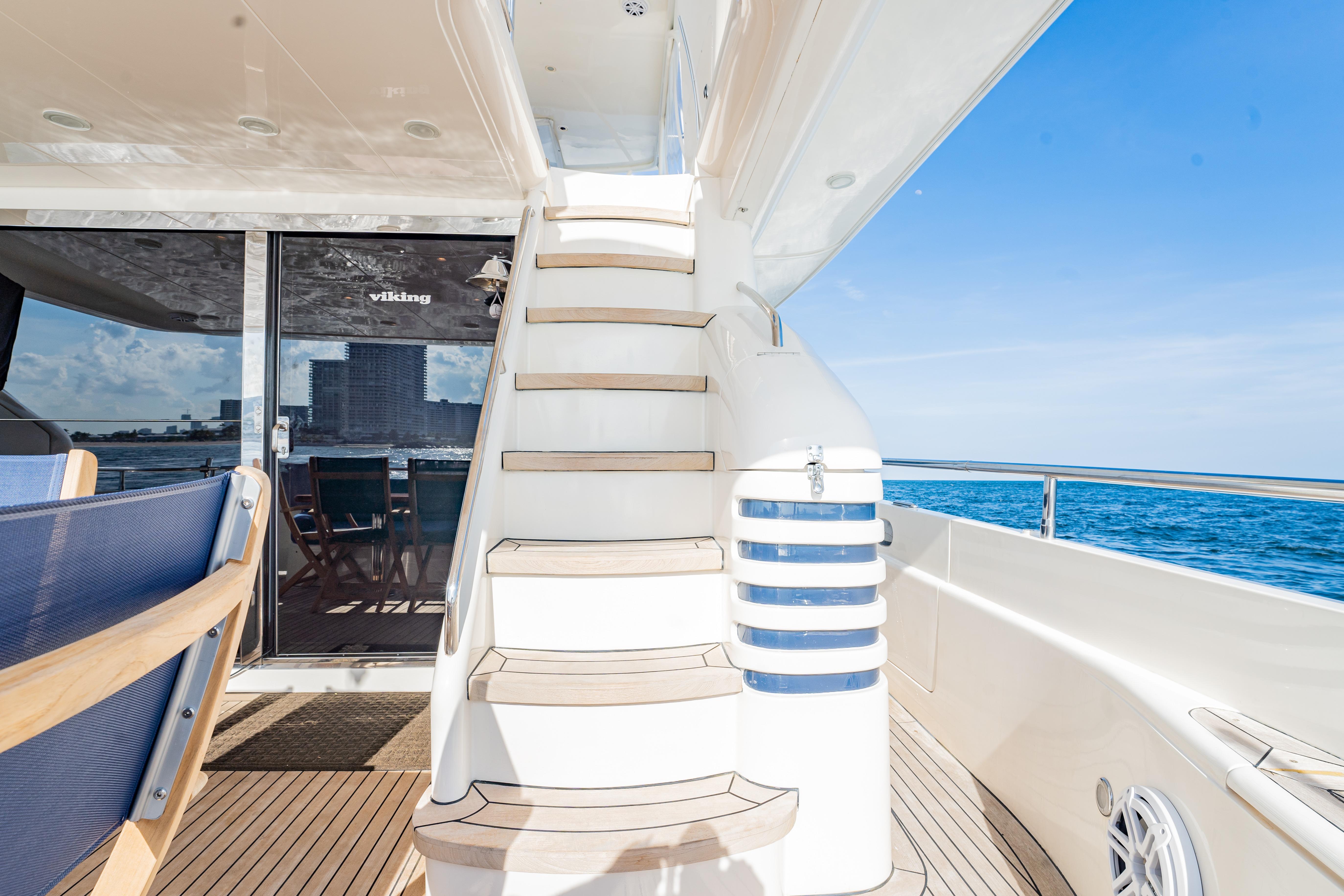 2004 Viking Princess Flybridge yacht with elegant staircase and ocean view.