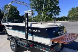 1996 MasterCraft ProStar 190 boat on trailer, featuring sleek design and wooden swim platform.