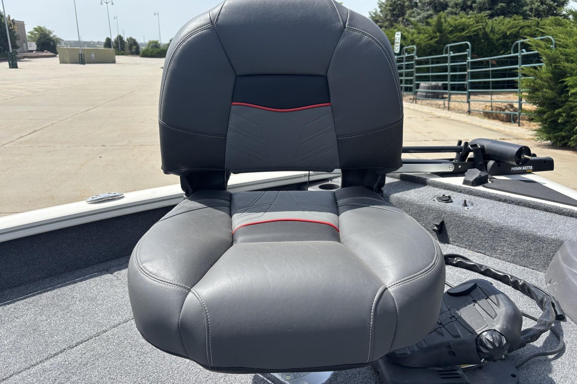 2024 Tracker Pro Team 175 TF boat seat, gray with red accents, outdoor setting.