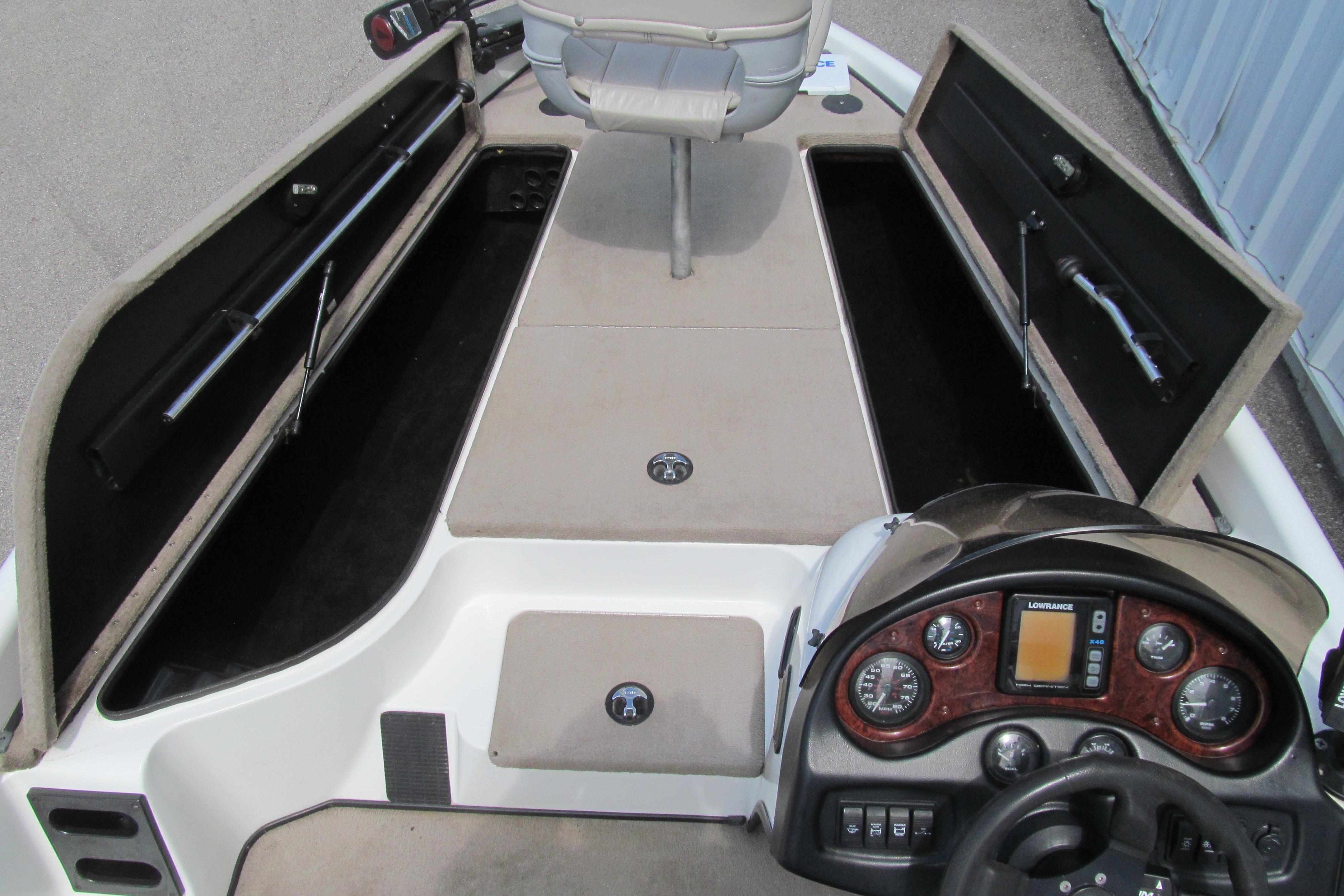 2002 Triton Tr-176 SC boat interior with open storage compartments and control panel.