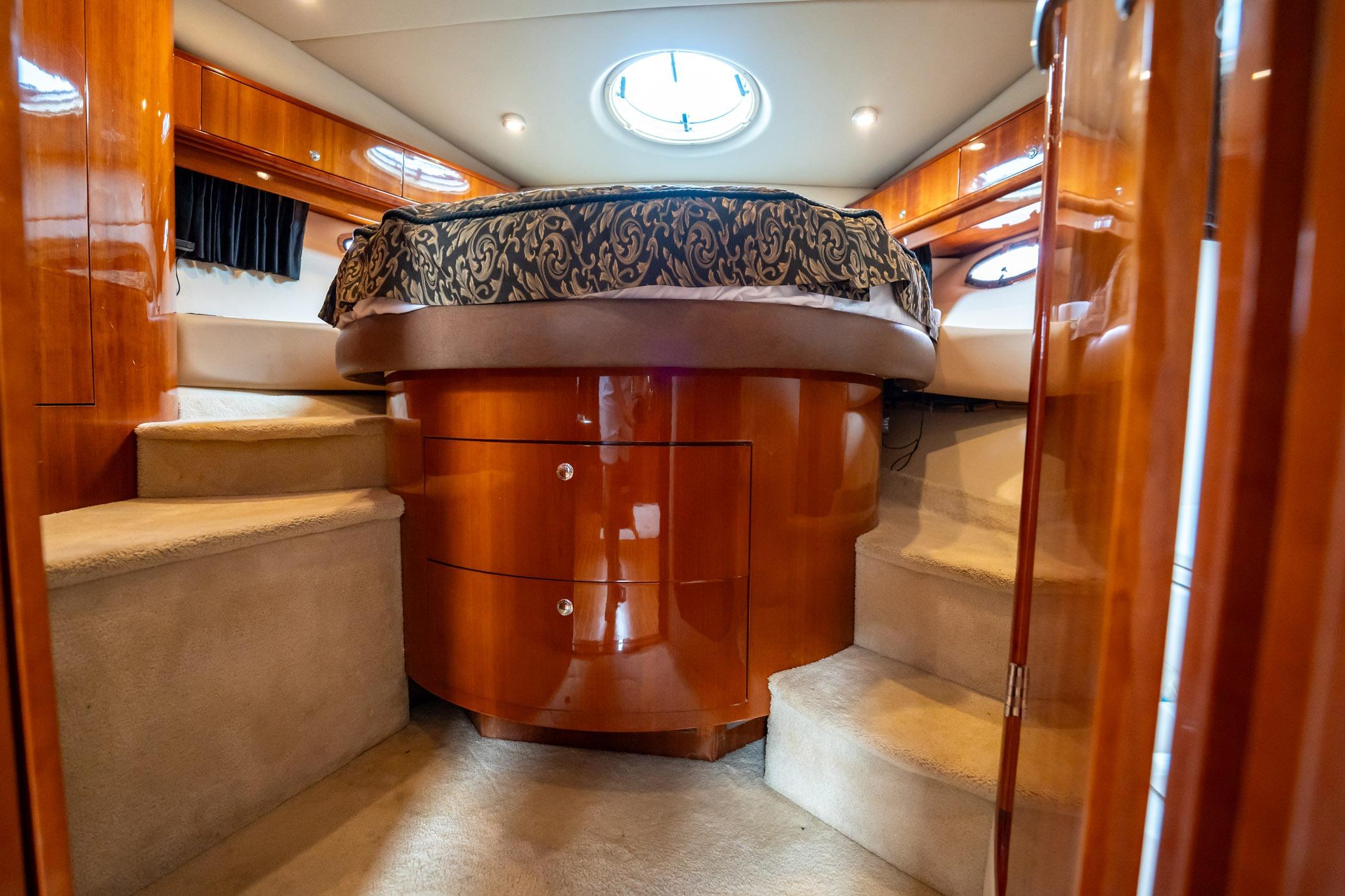 Luxurious 2008 Regal Commodore 4460 yacht interior with elegant wood finish and cozy bedding.