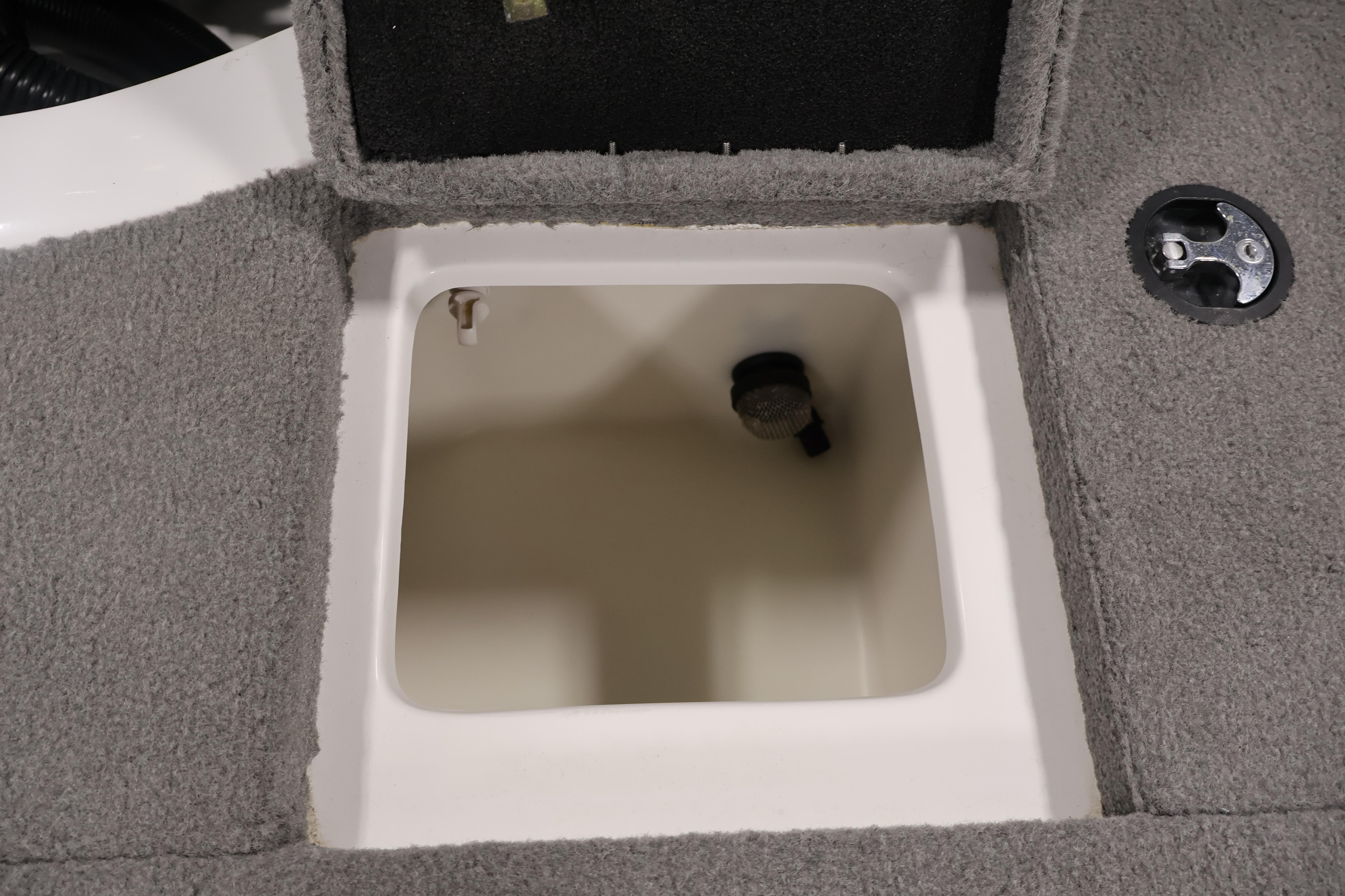 Open storage compartment in 2019 Nitro Z19 Sport boat, featuring gray carpeted interior.