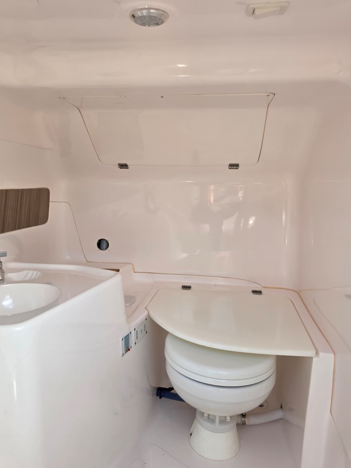 The image shows a modern boat bathroom with a toilet and sink.