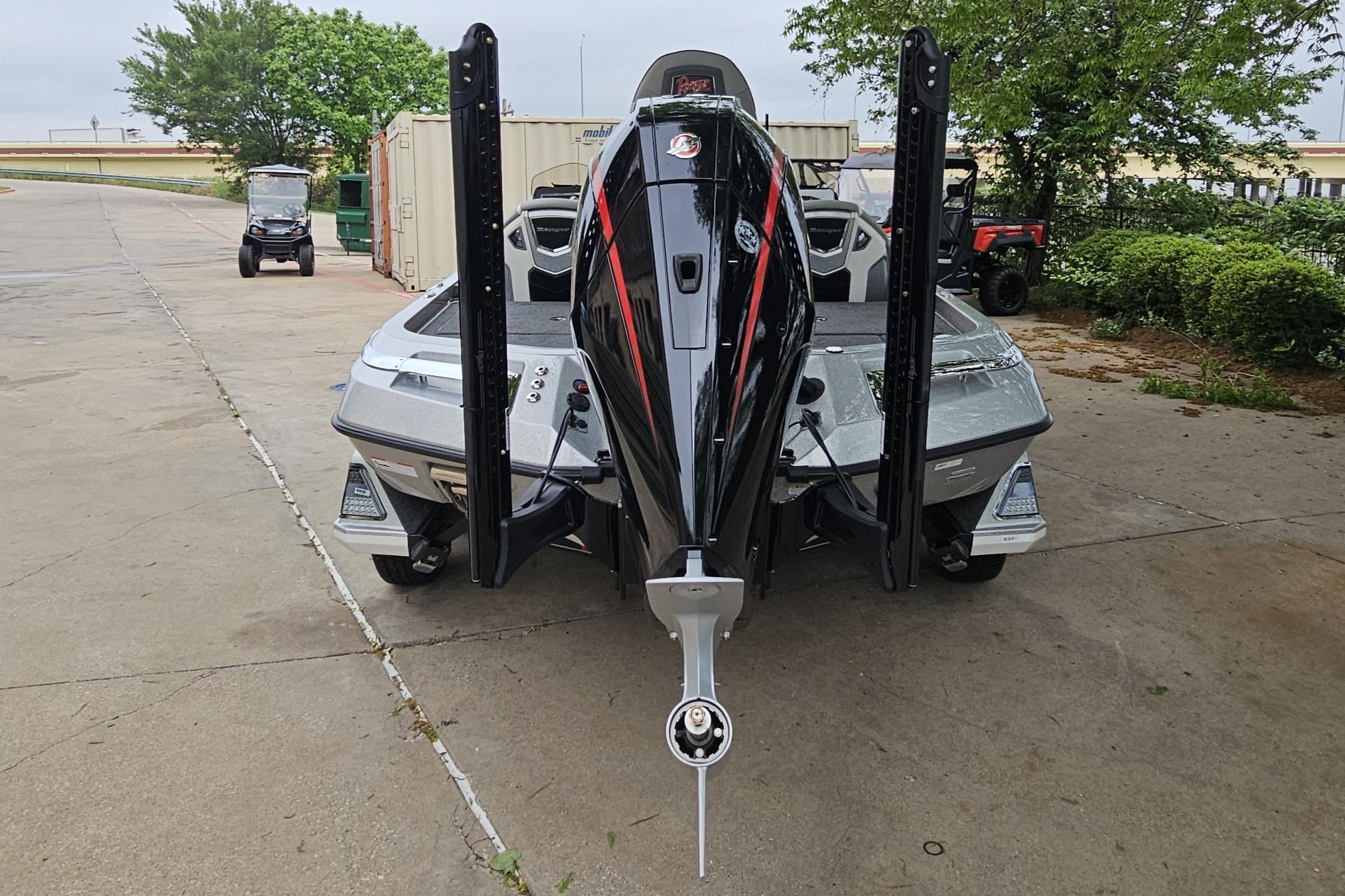 2026 Ranger Z521R Cup-Equipped boat, rear view, parked on concrete with greenery background.