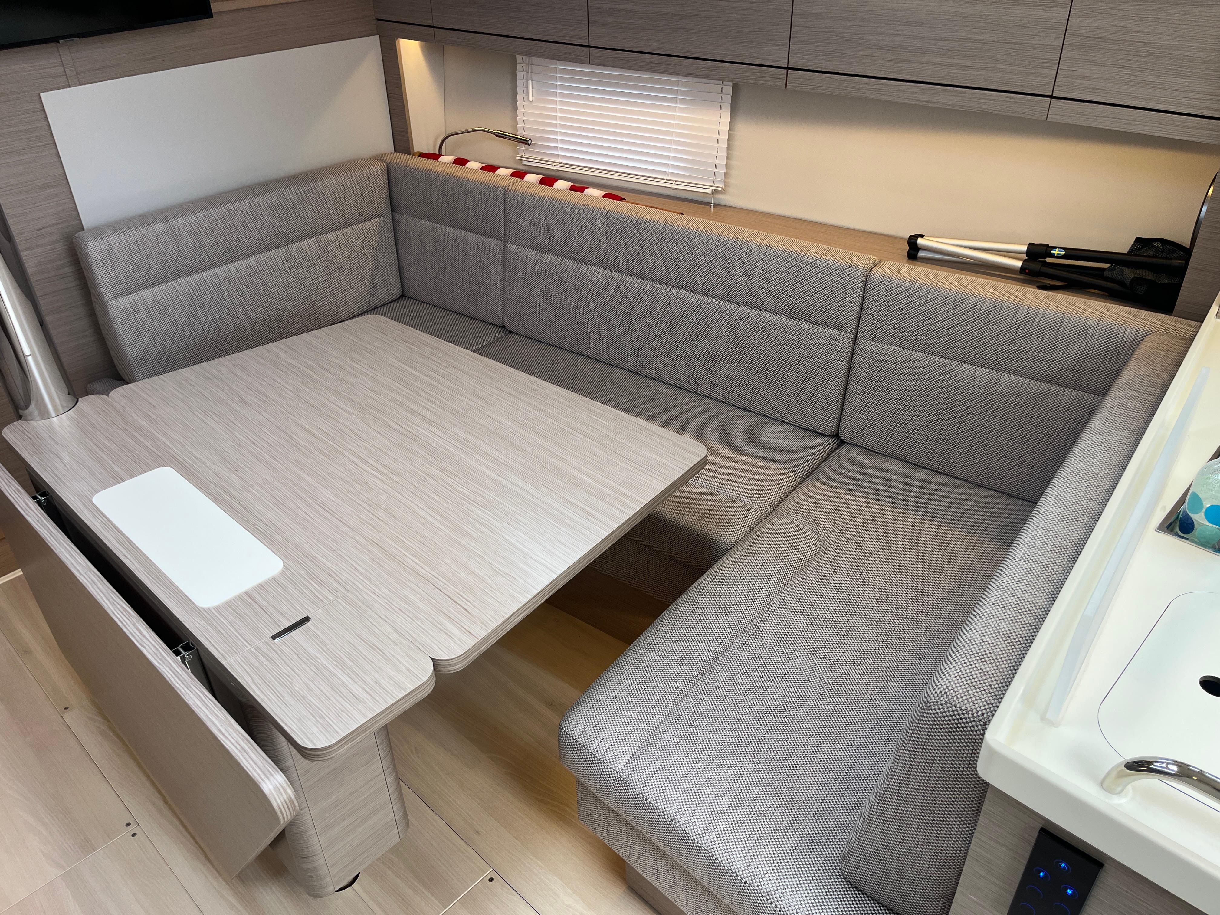 Modern interior of 2021 Hanse 418 yacht with cozy seating and dining area.