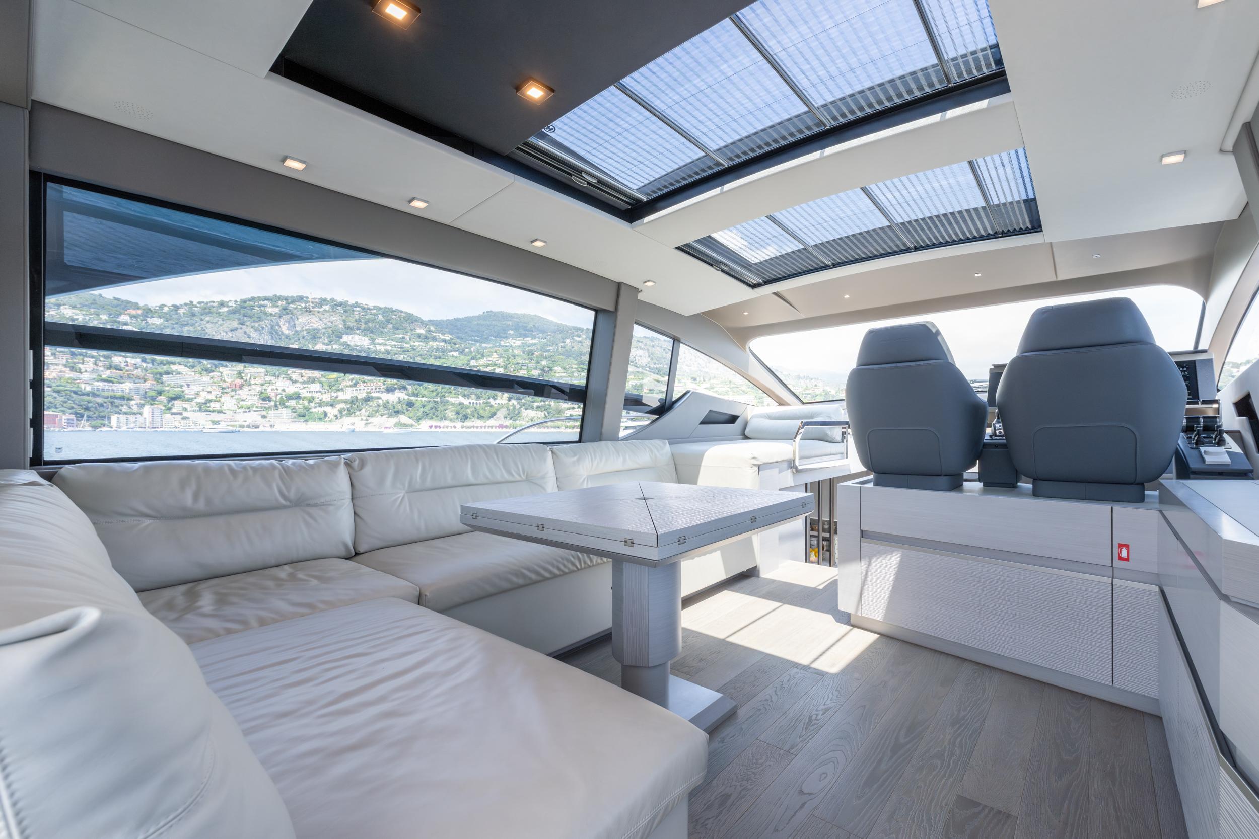 Luxurious interior of 2024 Pershing 7X yacht with panoramic windows and modern seating.