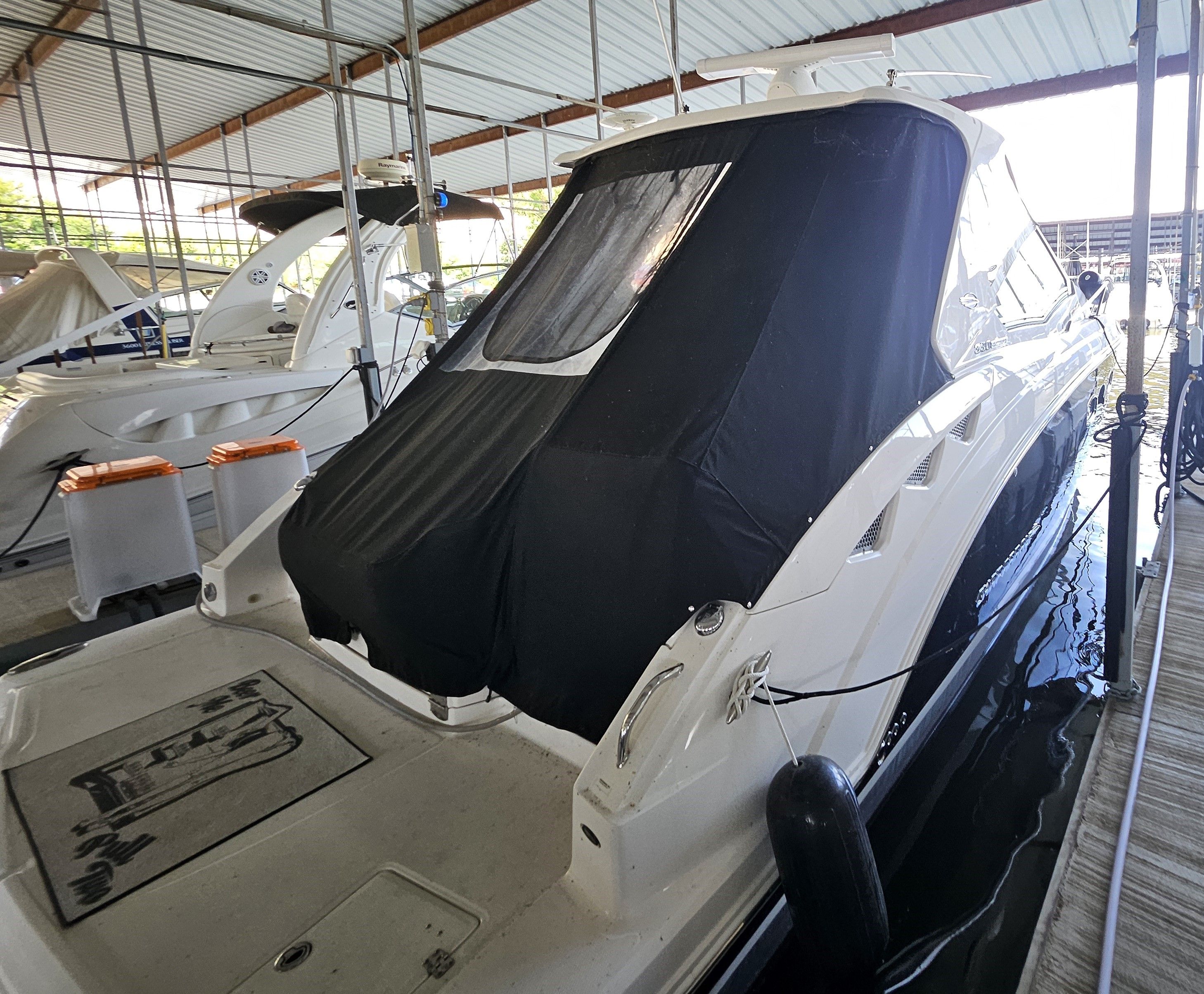 2014 Chaparral 330 Signature yacht docked with black cover.