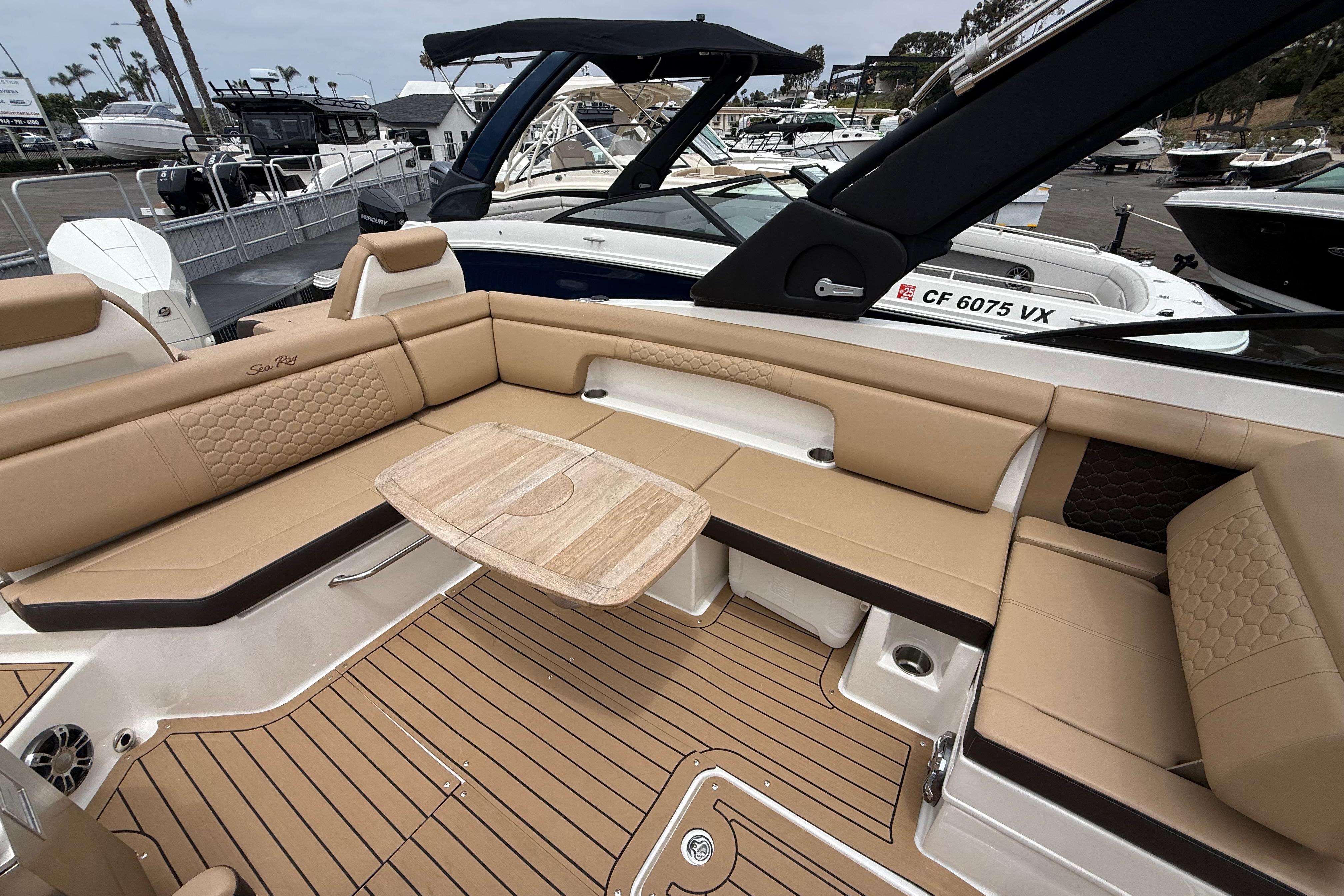 2022 Sea Ray SDX 290 Outboard boat interior with tan seating and wooden table.