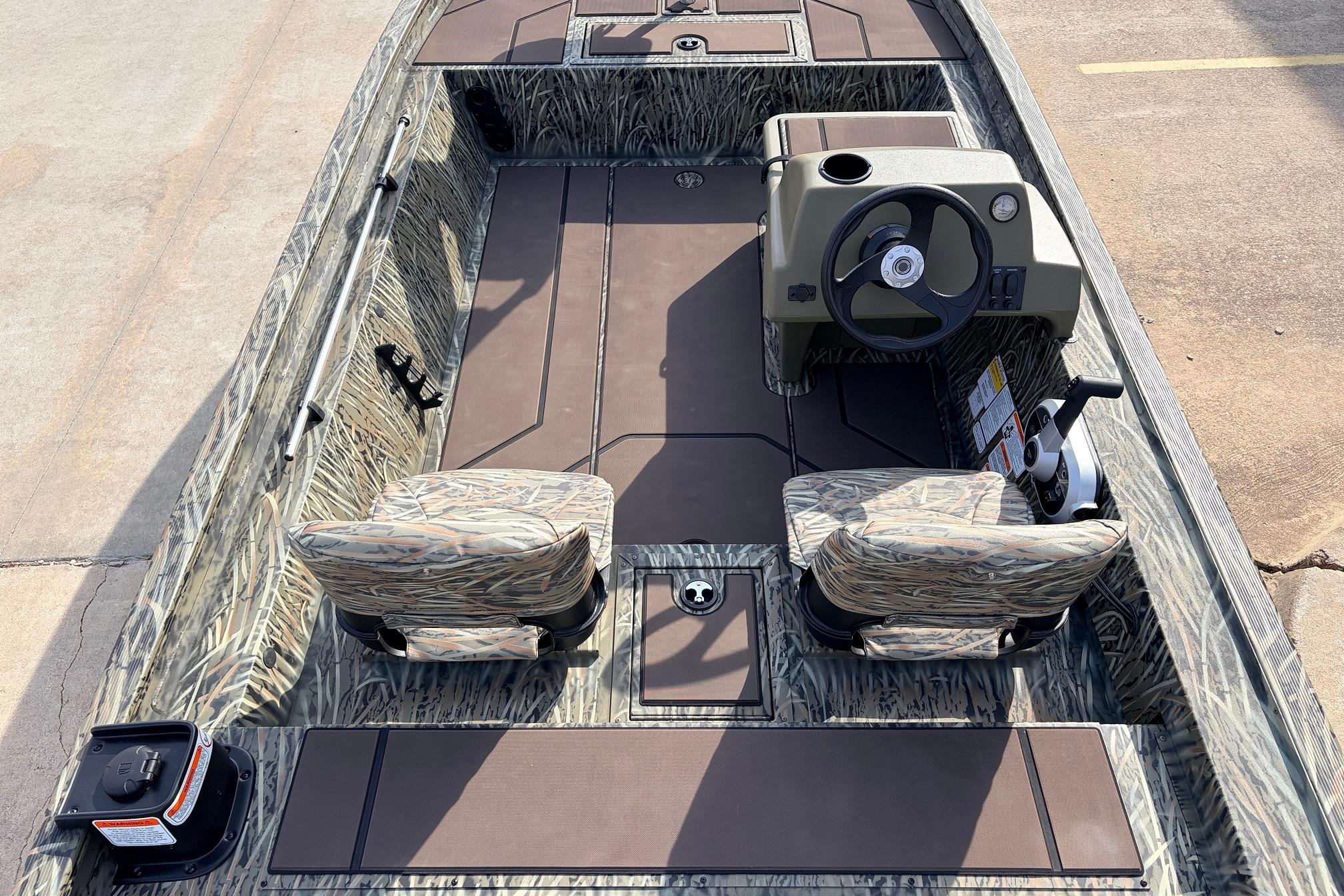 2026 Tracker Grizzly 1754 SC boat interior with camo seats and steering console.