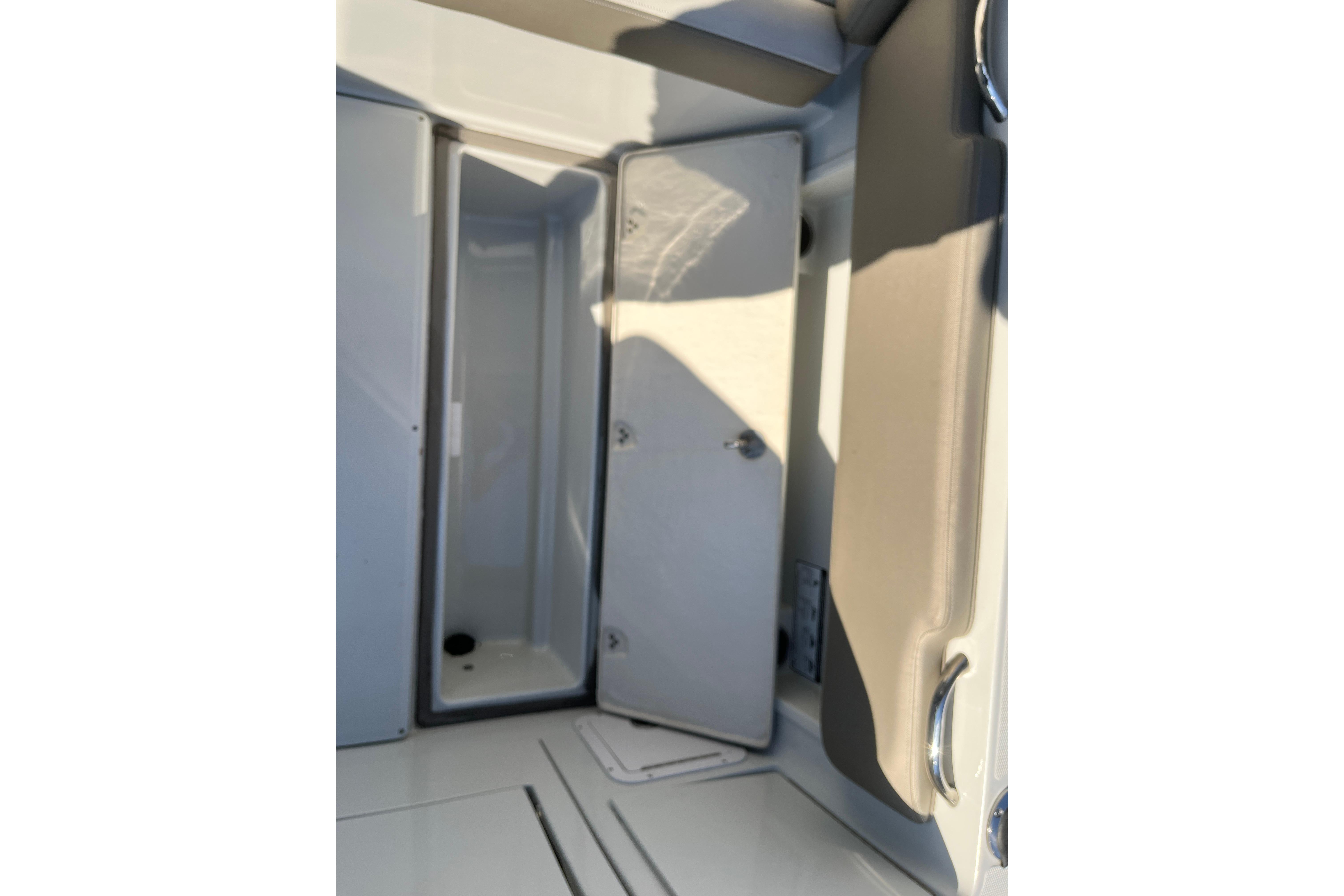 2022 Finseeker 280 DC boat interior storage compartment with open door.