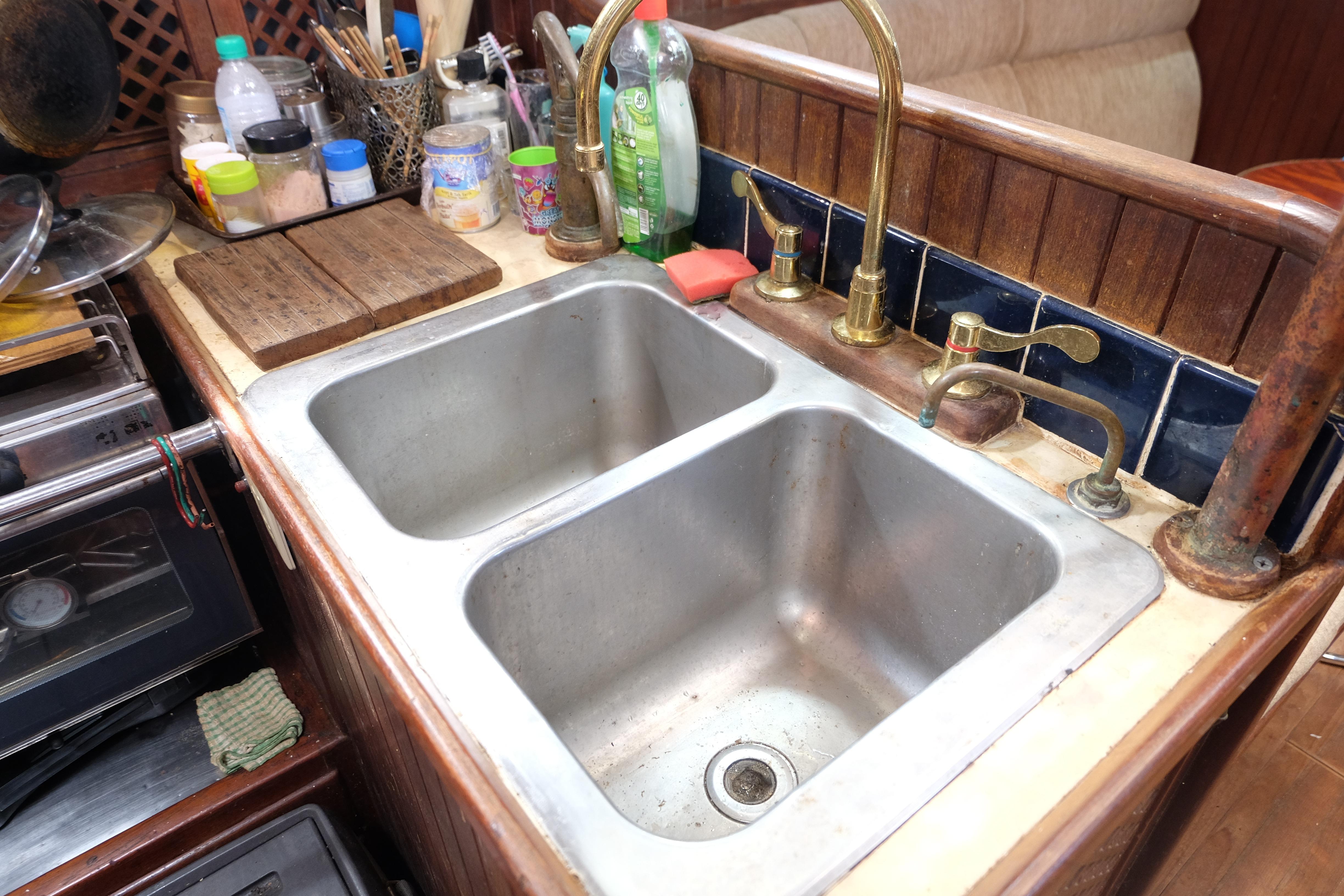 1979 Westwind 35 yacht kitchen sink with dual basins and brass faucets.