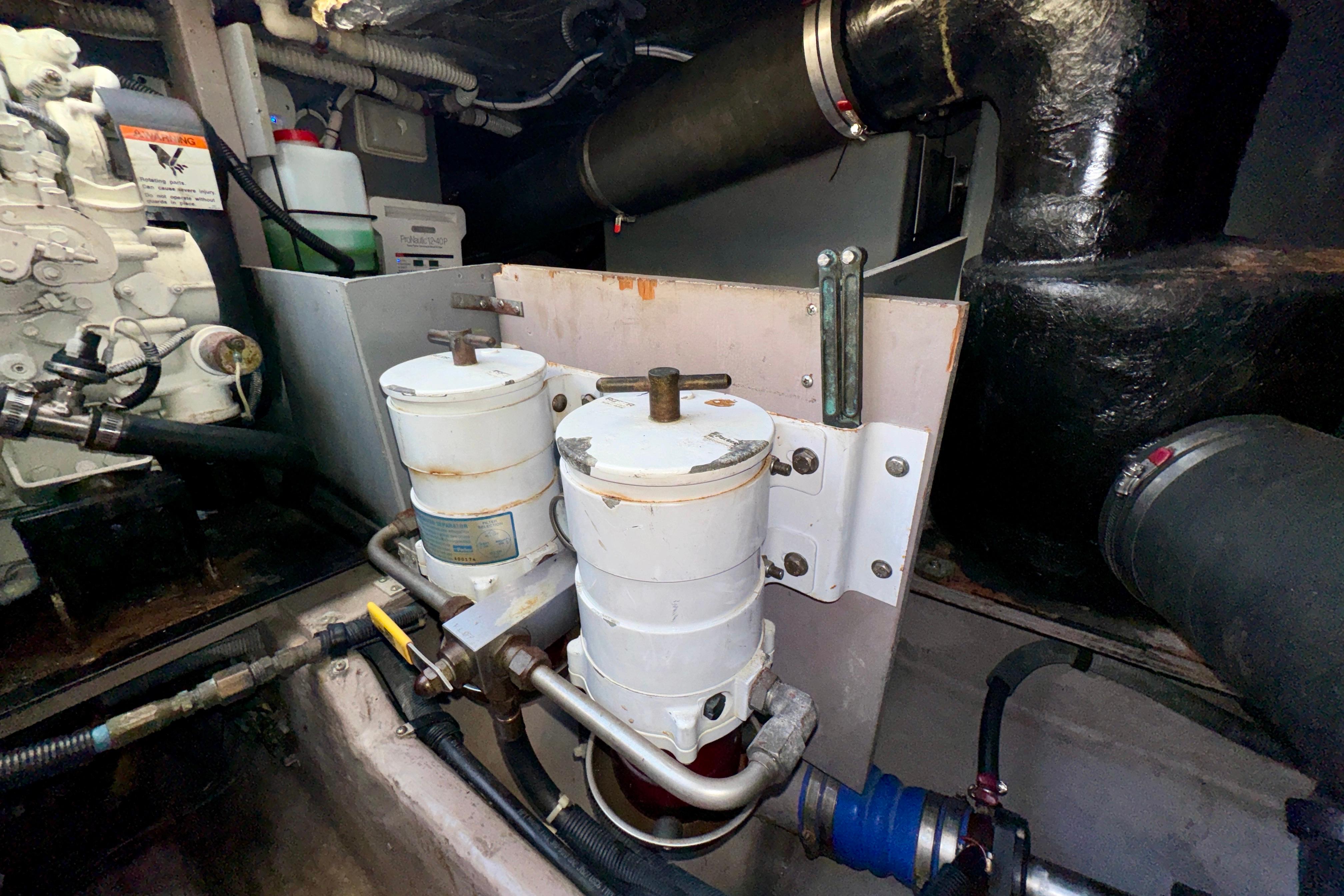 Engine room of 2003 Sea Ray 400 Sedan Bridge with fuel filters and piping.