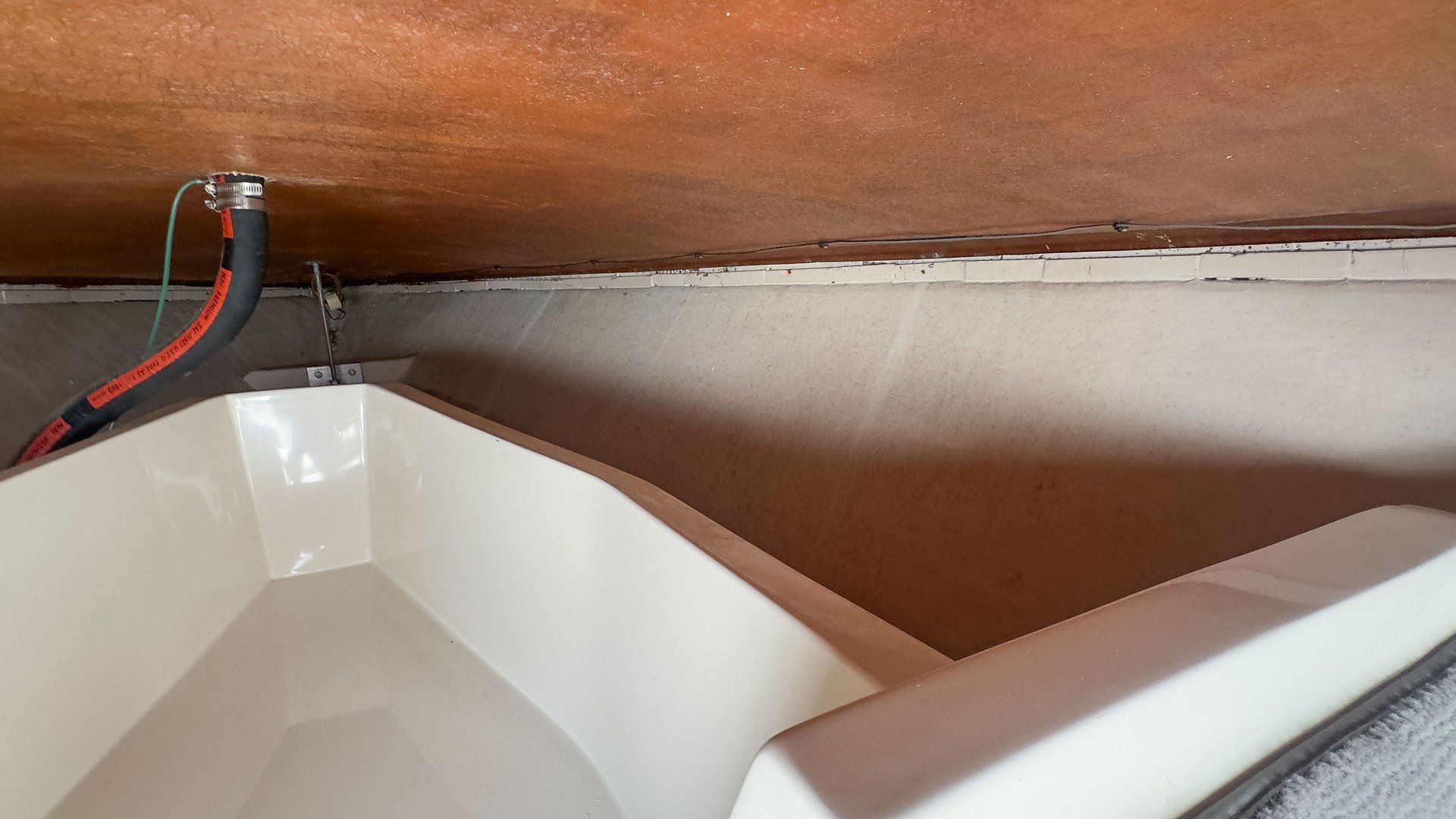 Close-up of a boat's interior with white surfaces and wooden elements.