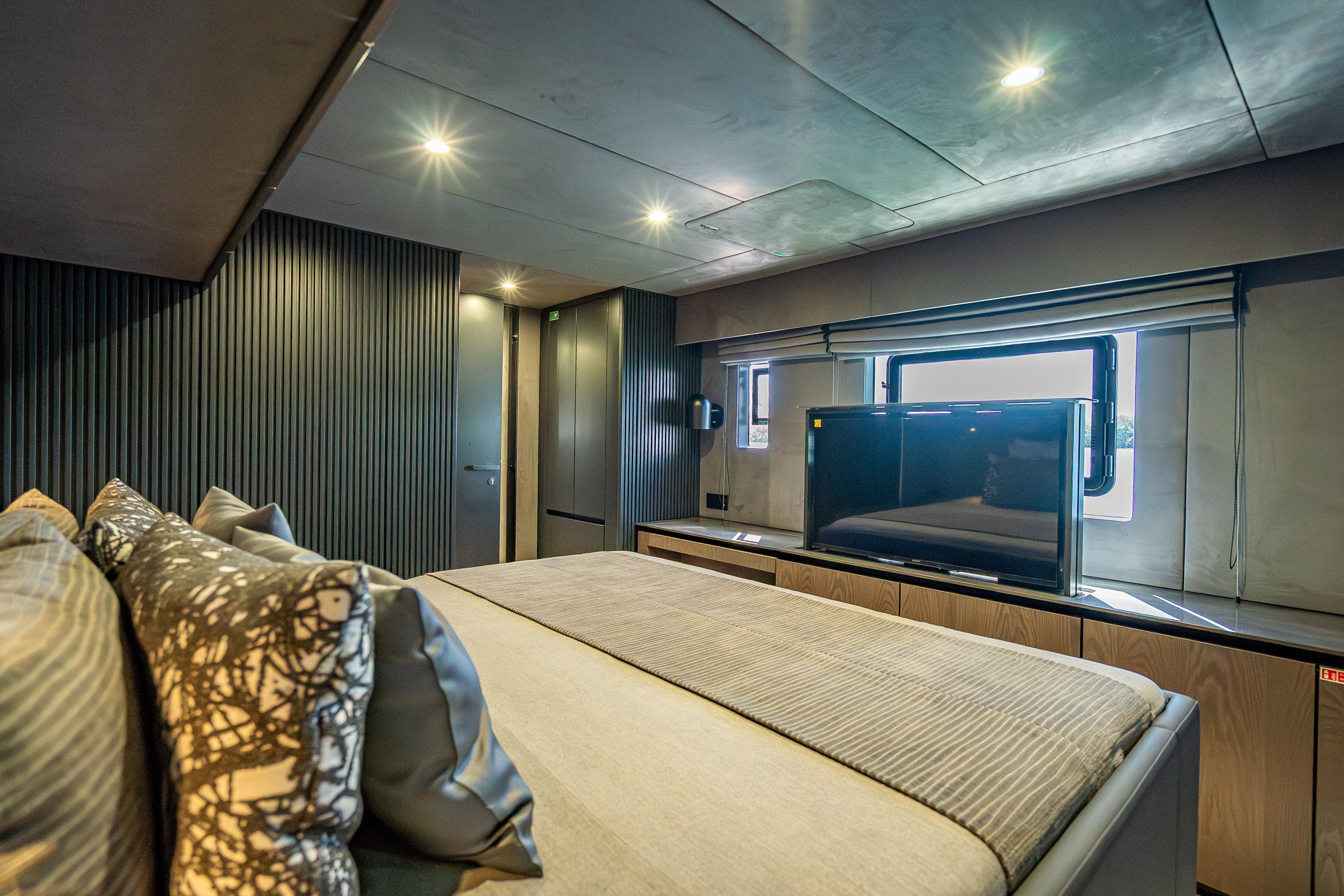 Luxurious Sunreef 60 Power 2026 yacht bedroom with modern decor and large window.