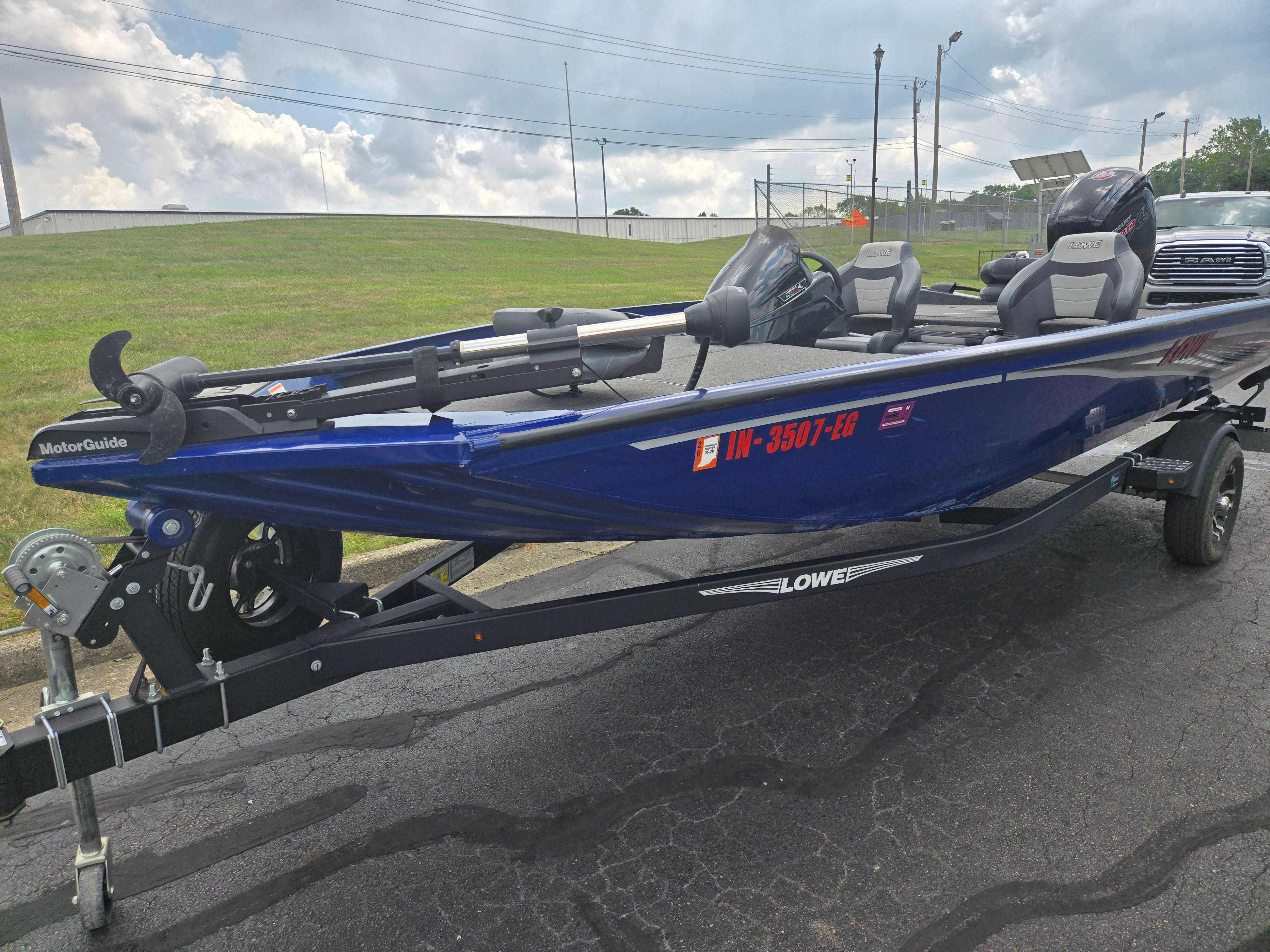 2021 Lowe Stinger 188 boat on trailer, blue exterior, parked on asphalt.
