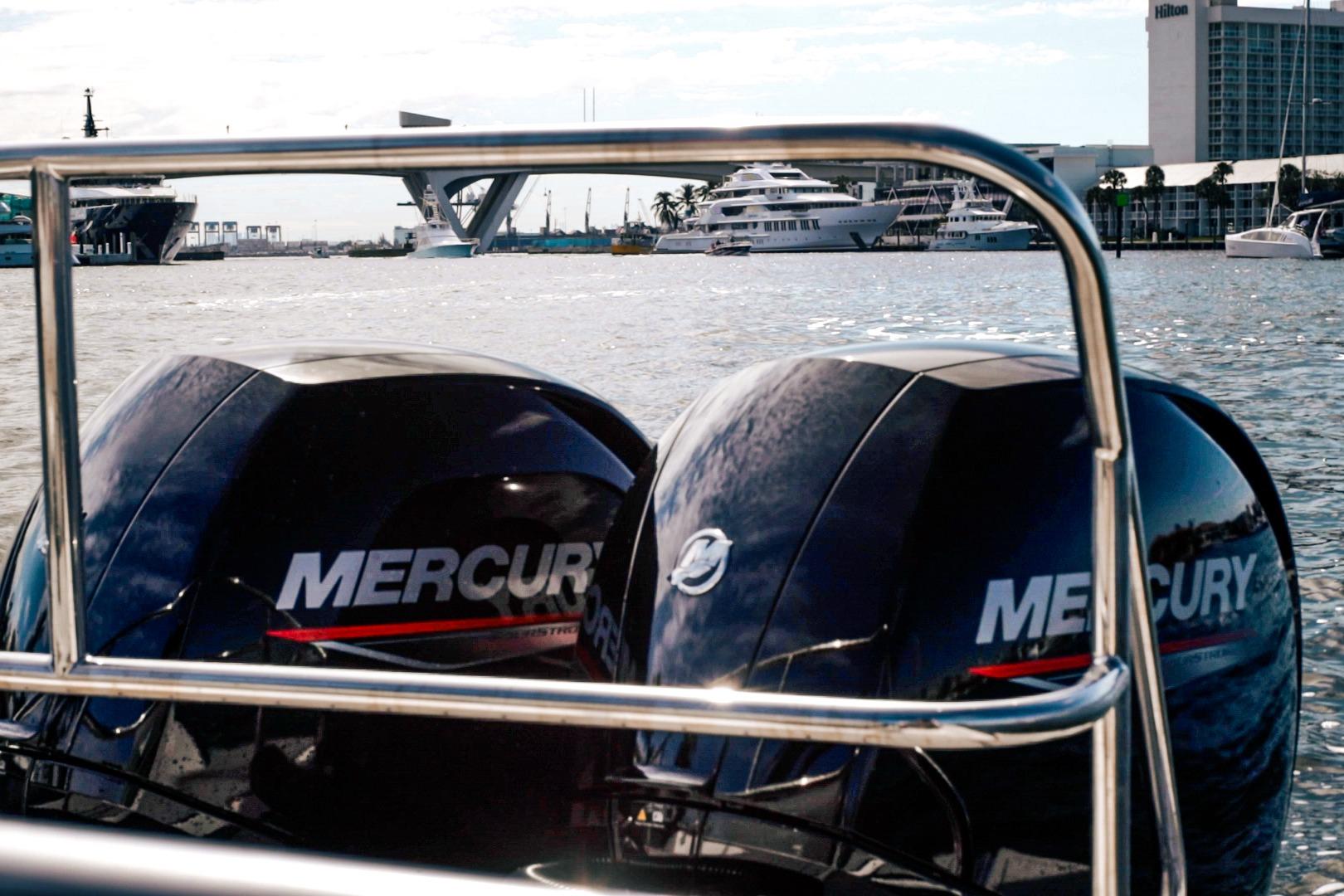 Twin Mercury outboard motors on a Hanover 305 boat, 2027, docked near luxury yachts.