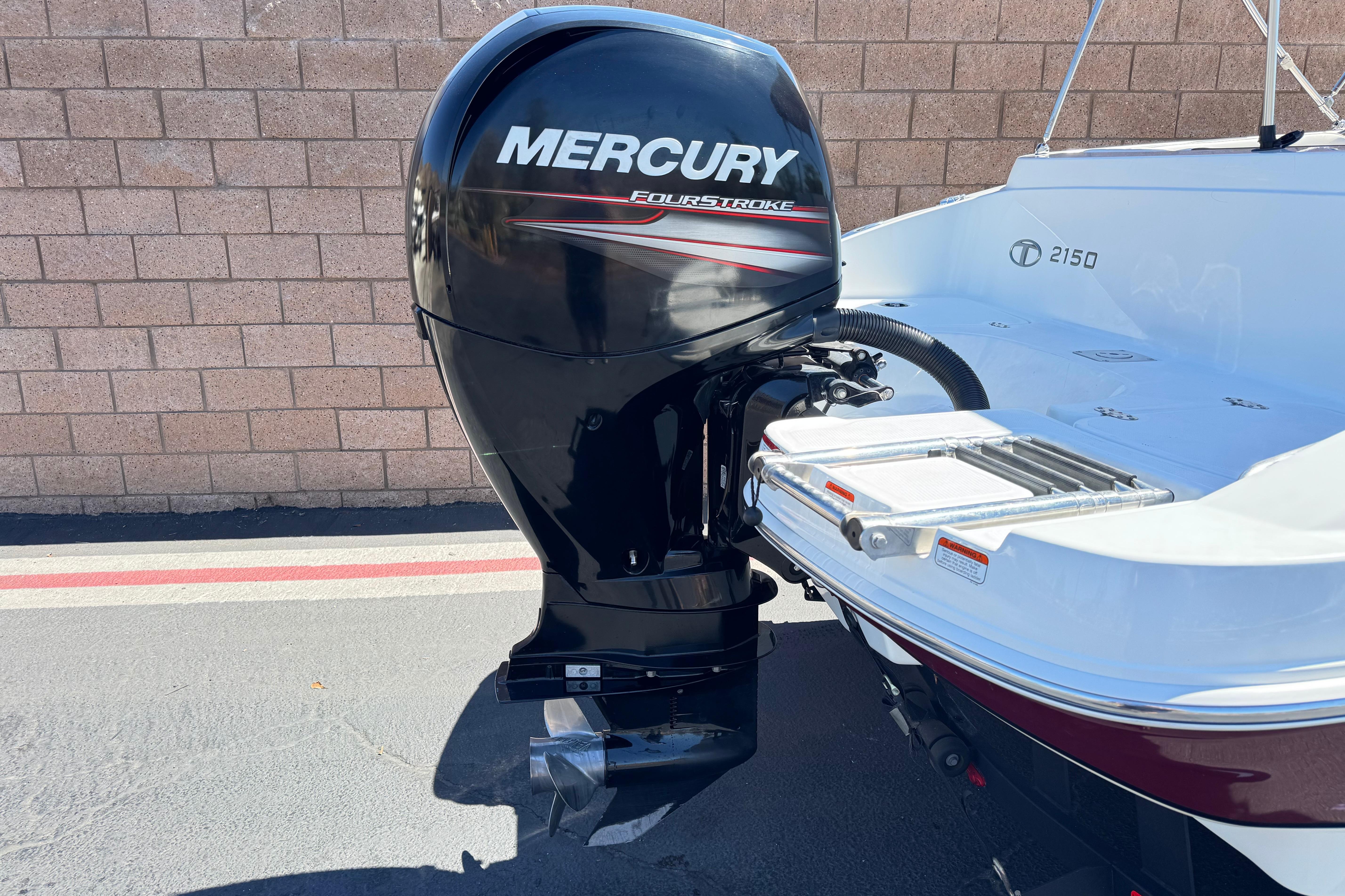 2017 Tahoe 2150 boat with Mercury FourStroke outboard motor, parked near a brick wall.