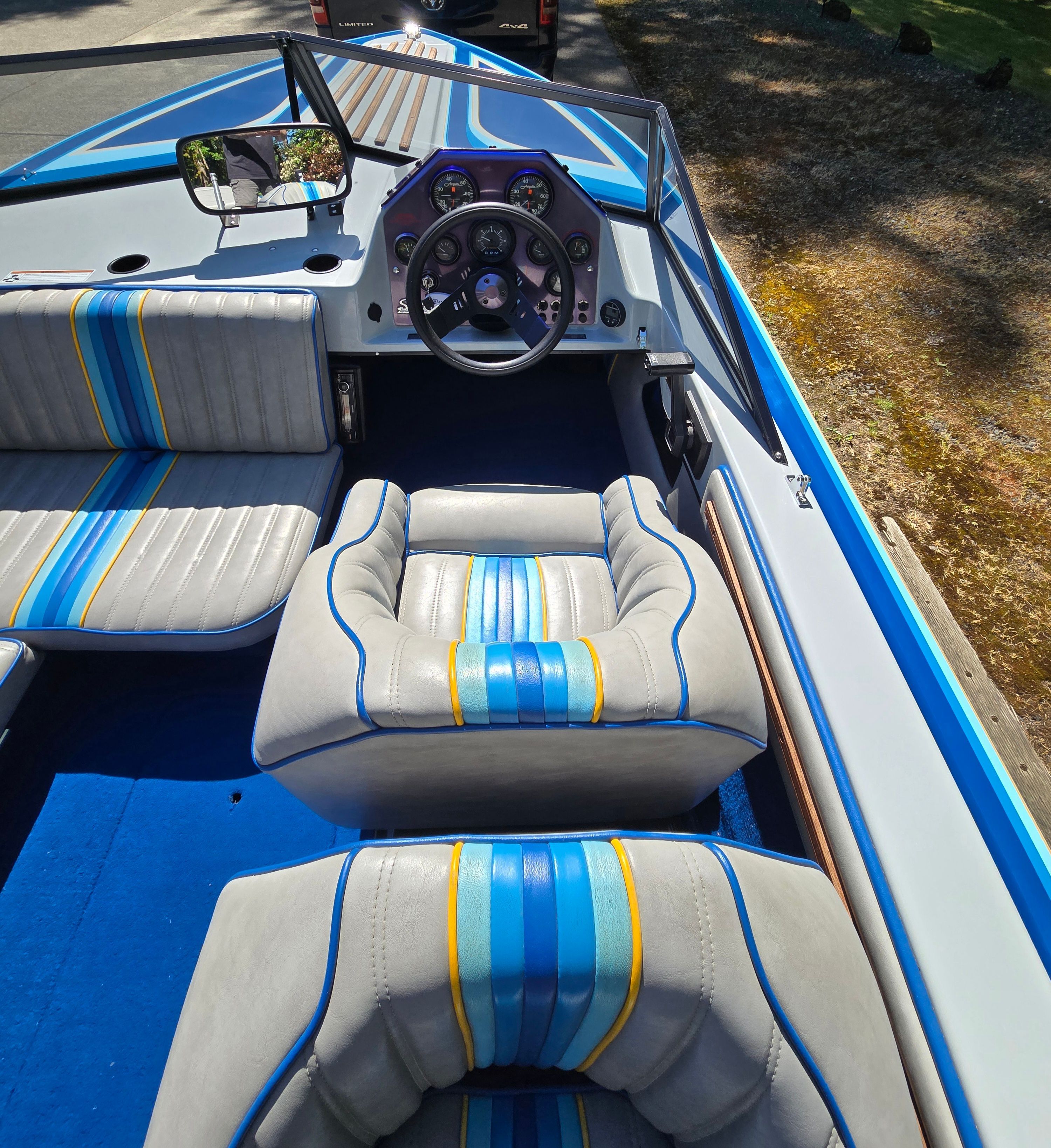 Interior view of a 1990 Sanger Ski Sanger with blue-gray seats and colorful stripes.
