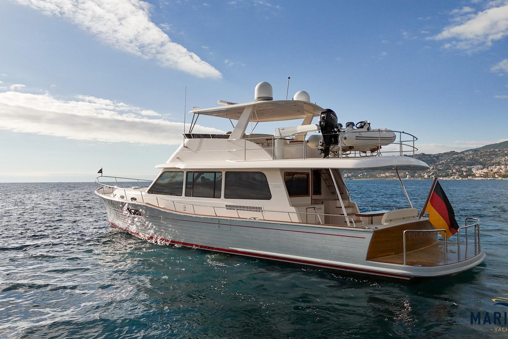 2023 Grand Banks 60 yacht cruising on open water under a clear sky.