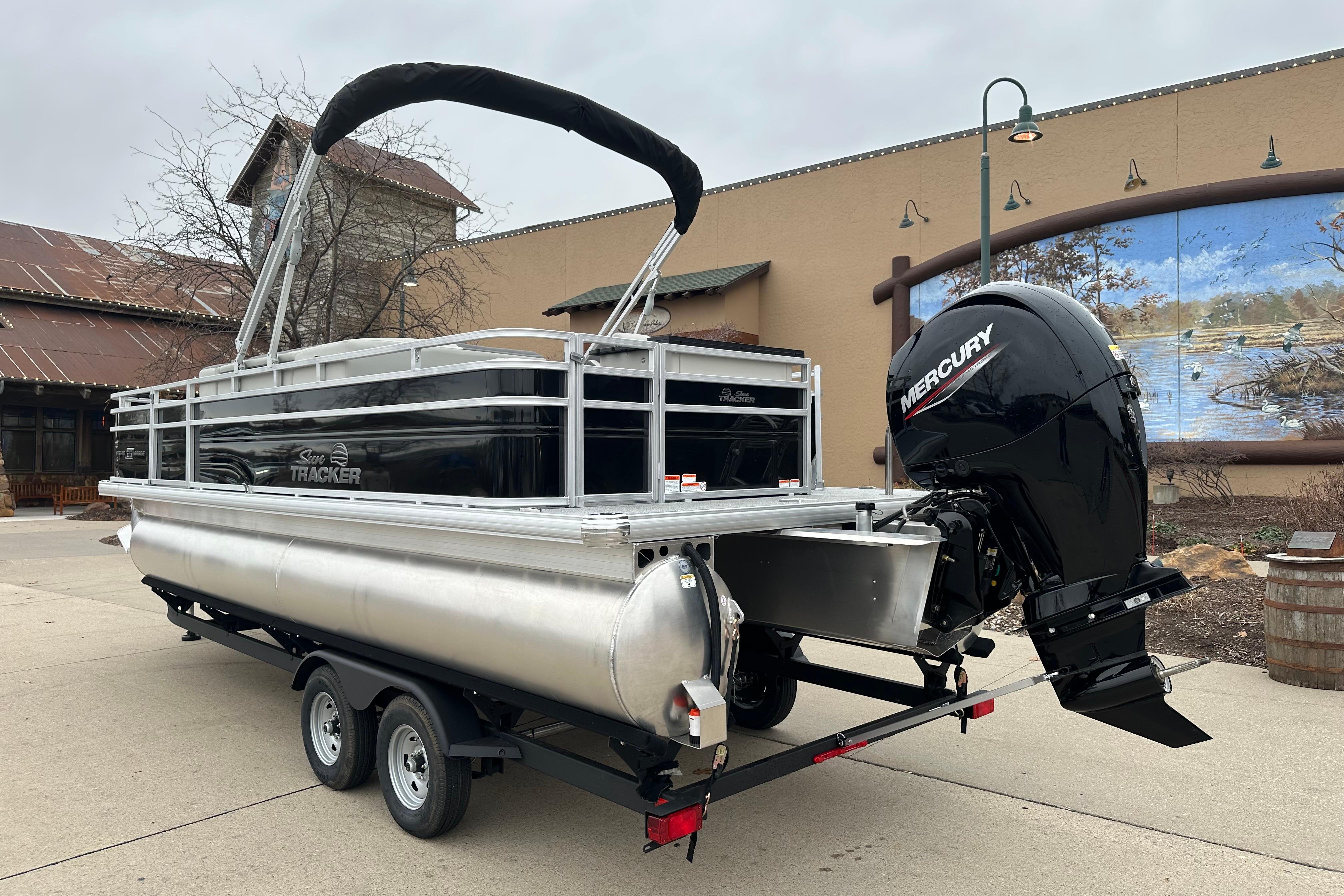 2026 Sun Tracker Fishin' Barge 22 DLX pontoon boat with Mercury engine on trailer.