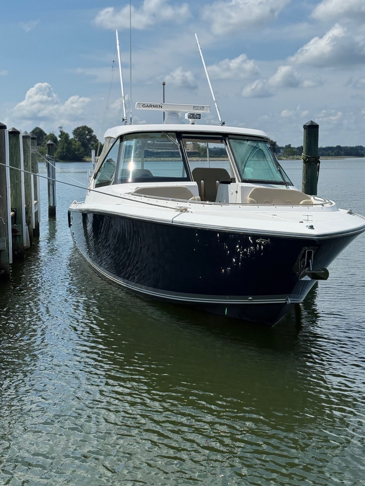A 2016 Pursuit DC 325 Dual Console boat docked in calm waters.