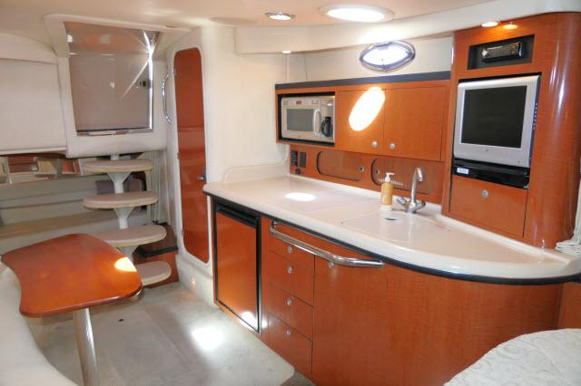 2005 Sea Ray 340 Sundancer interior with kitchenette, microwave, and TV.