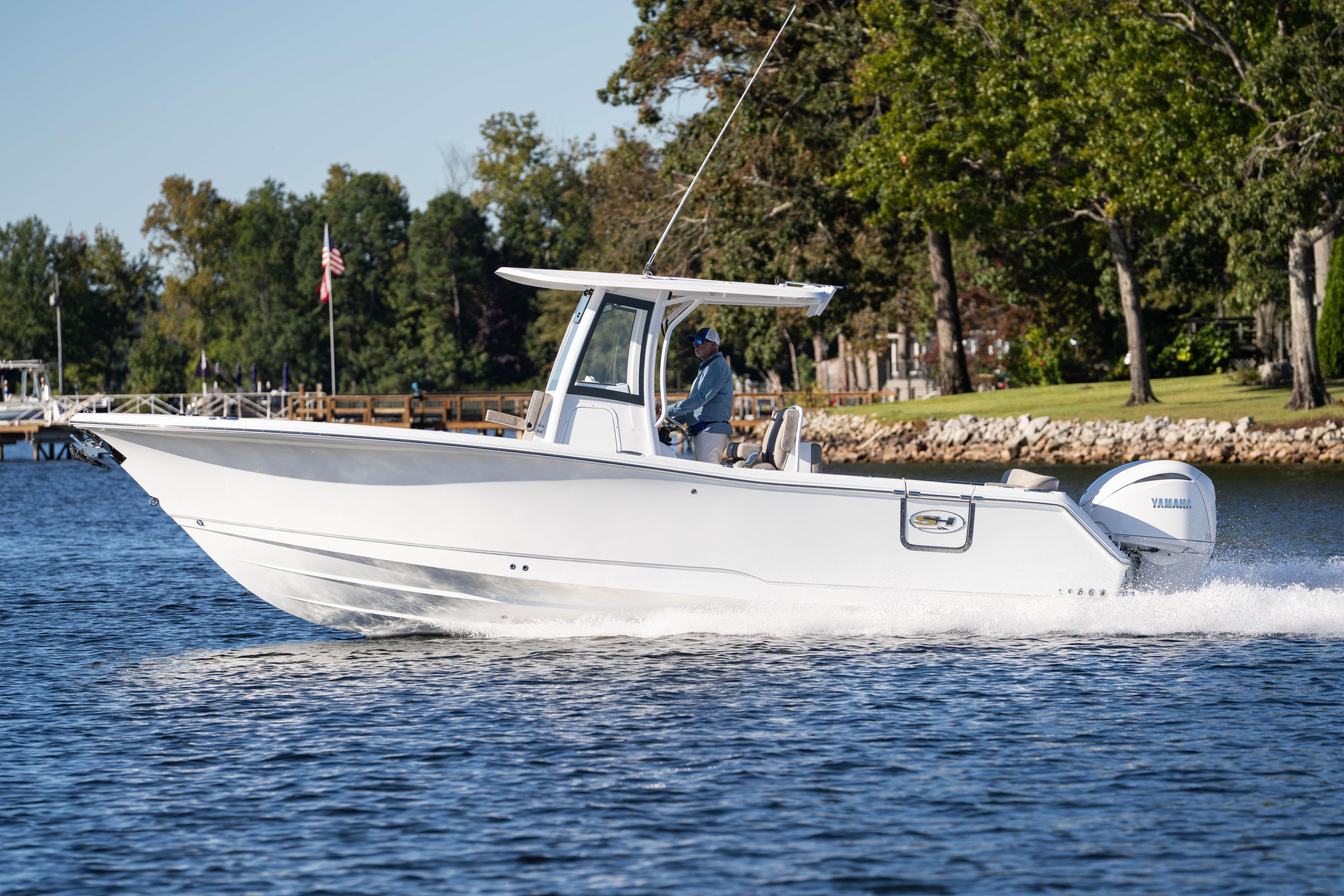2026 Sea Hunt Ultra 275 Coffin Box boat cruising on a scenic lake.