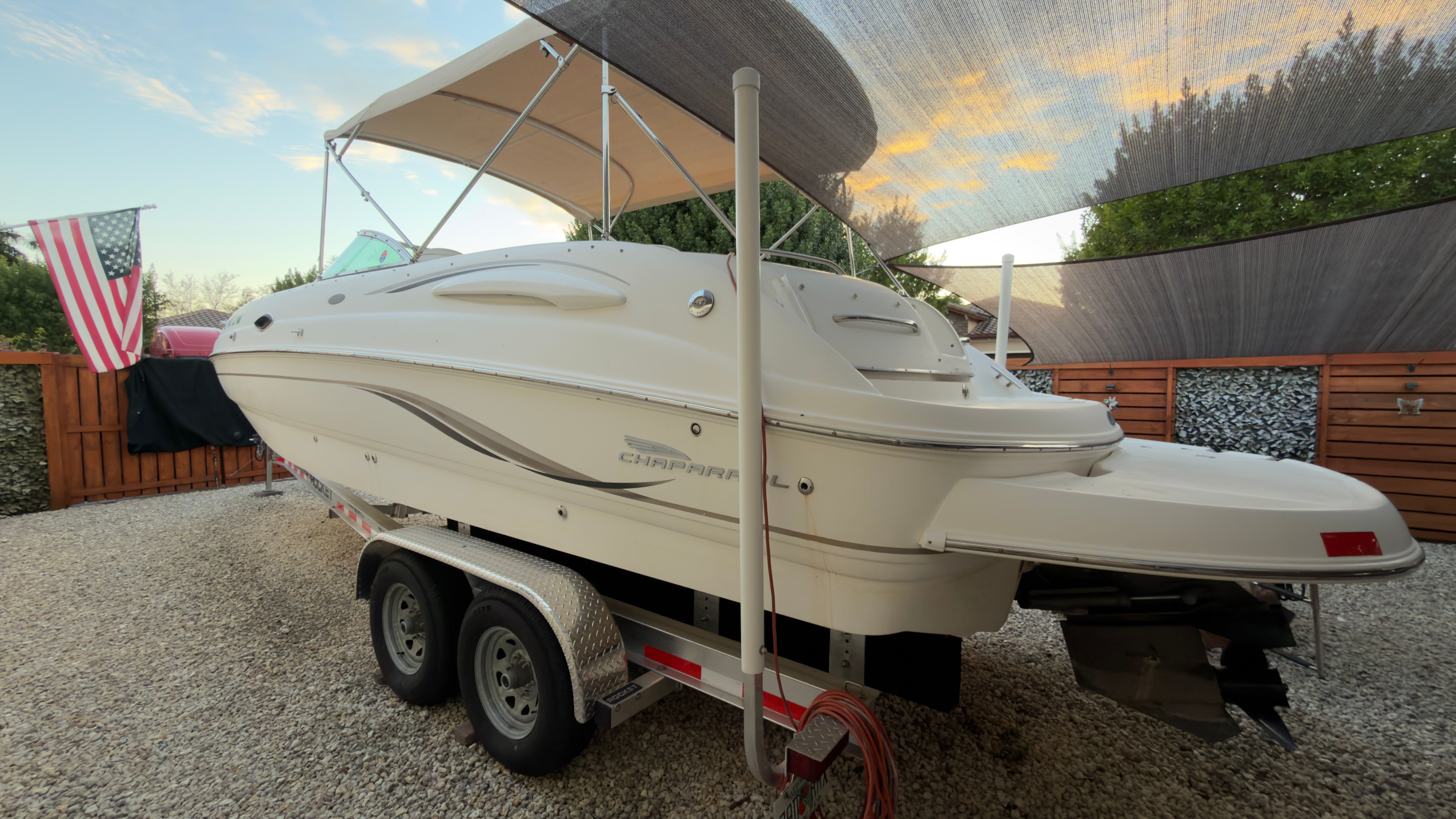 2003 Chaparral 263 Sunesta Deckboat on trailer in yard.