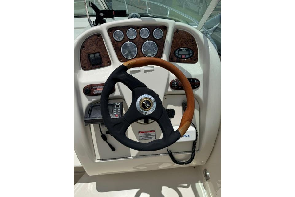 Steering console of a 2004 Sea Ray 240 Sundancer boat with gauges and controls.