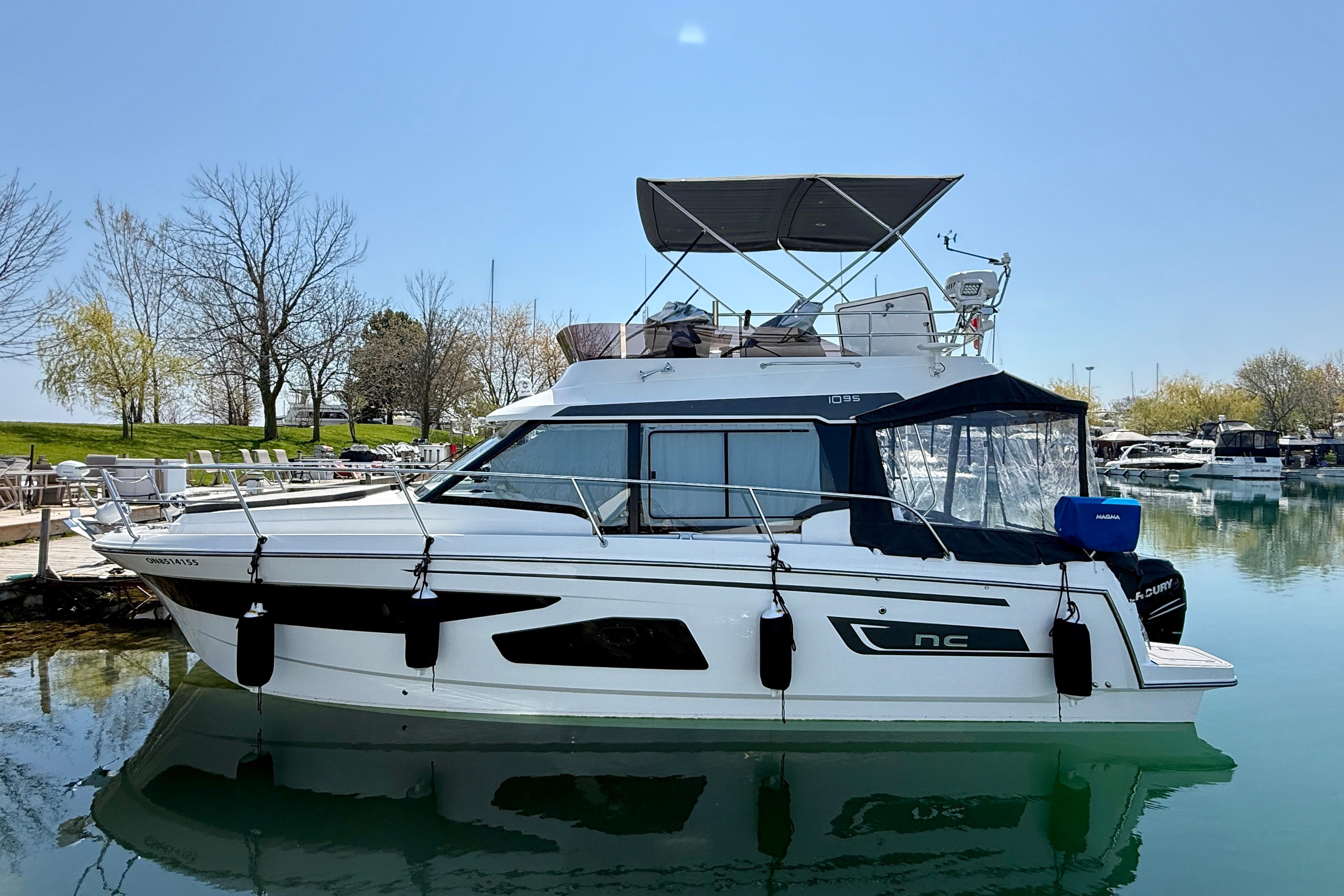 2022 Jeanneau NC 1095 Fly yacht docked in a serene marina setting.