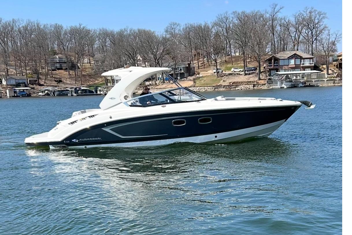 2018 Chaparral 347 SSX boat cruising on a lake with scenic shoreline background.