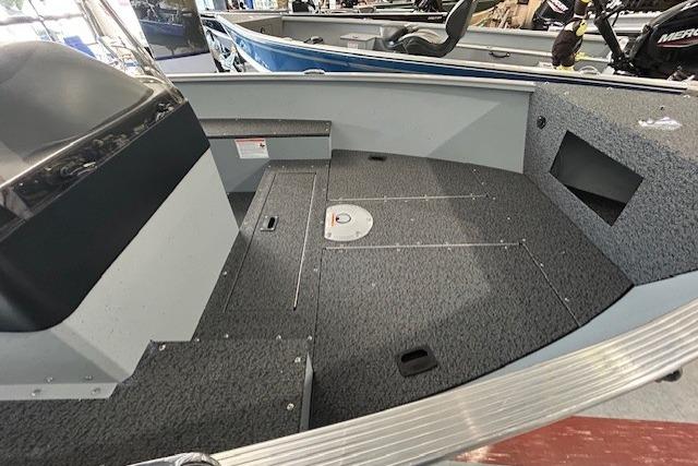 2027 Lund 1600 Fury SS boat interior with gray carpet and seating area.