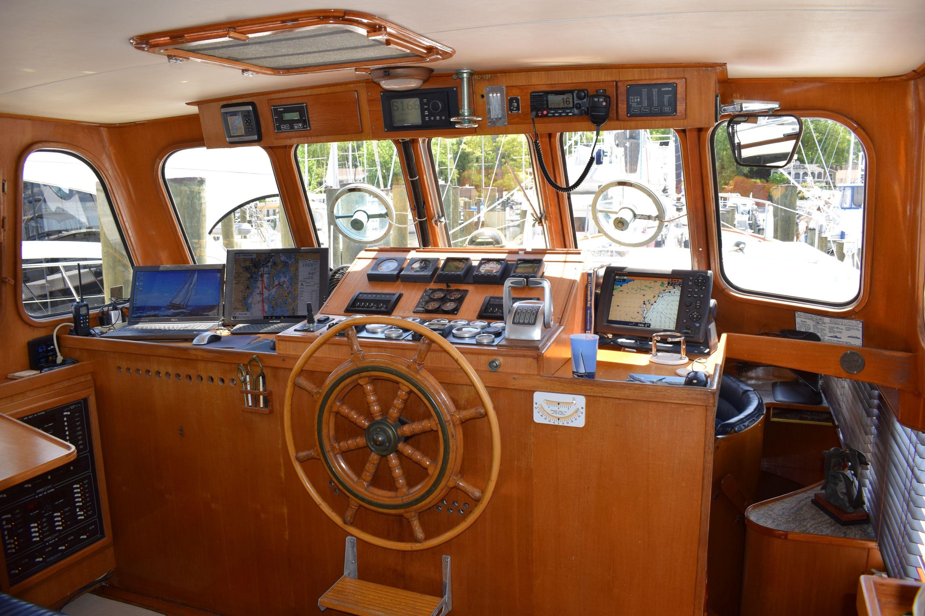 Interior of 1980 Cheoy Lee 52 Motorsailer with wooden helm and navigation equipment.