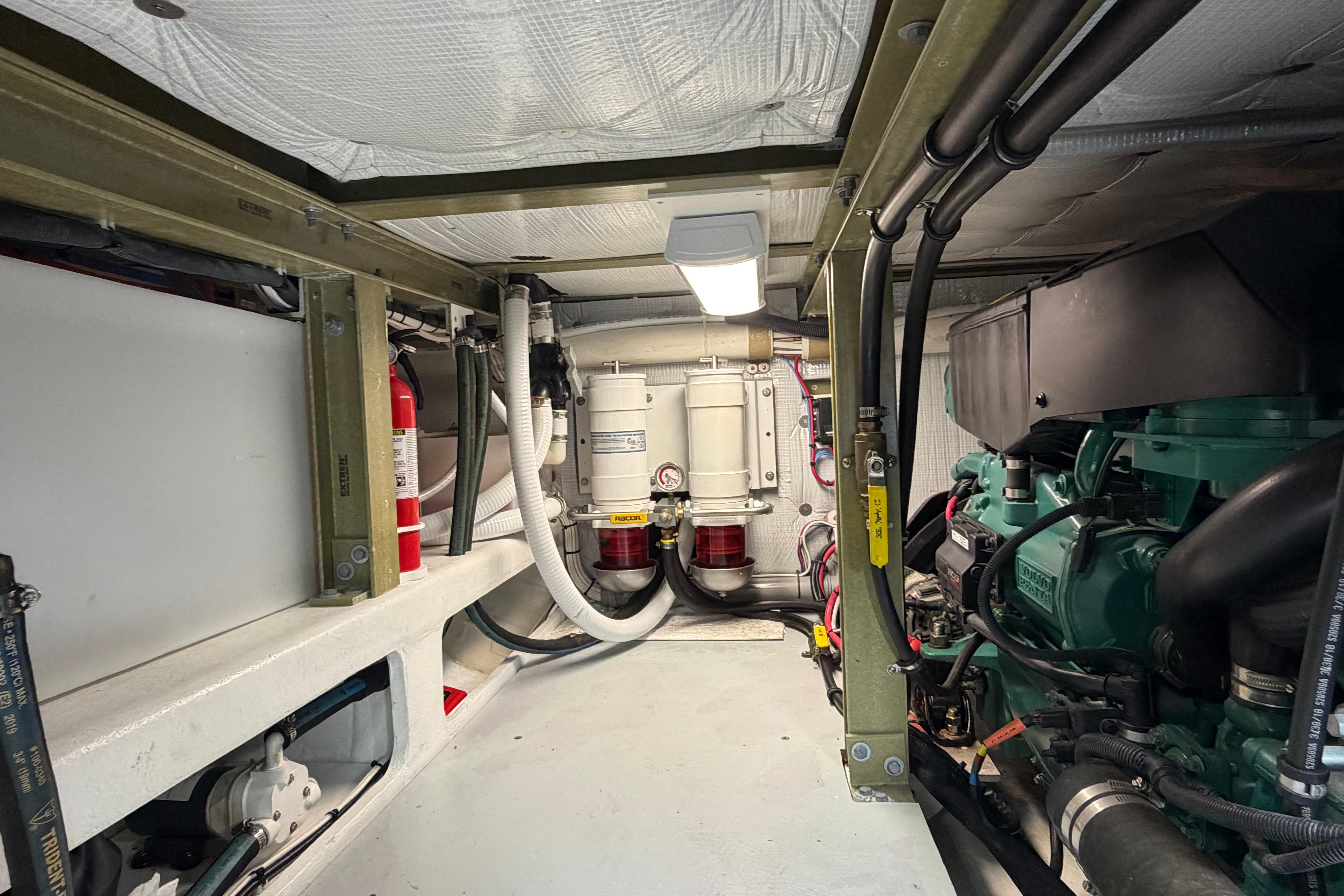 Engine room of a 2018 H&H Marine Osmond Beal boat, featuring mechanical components and fire extinguisher.