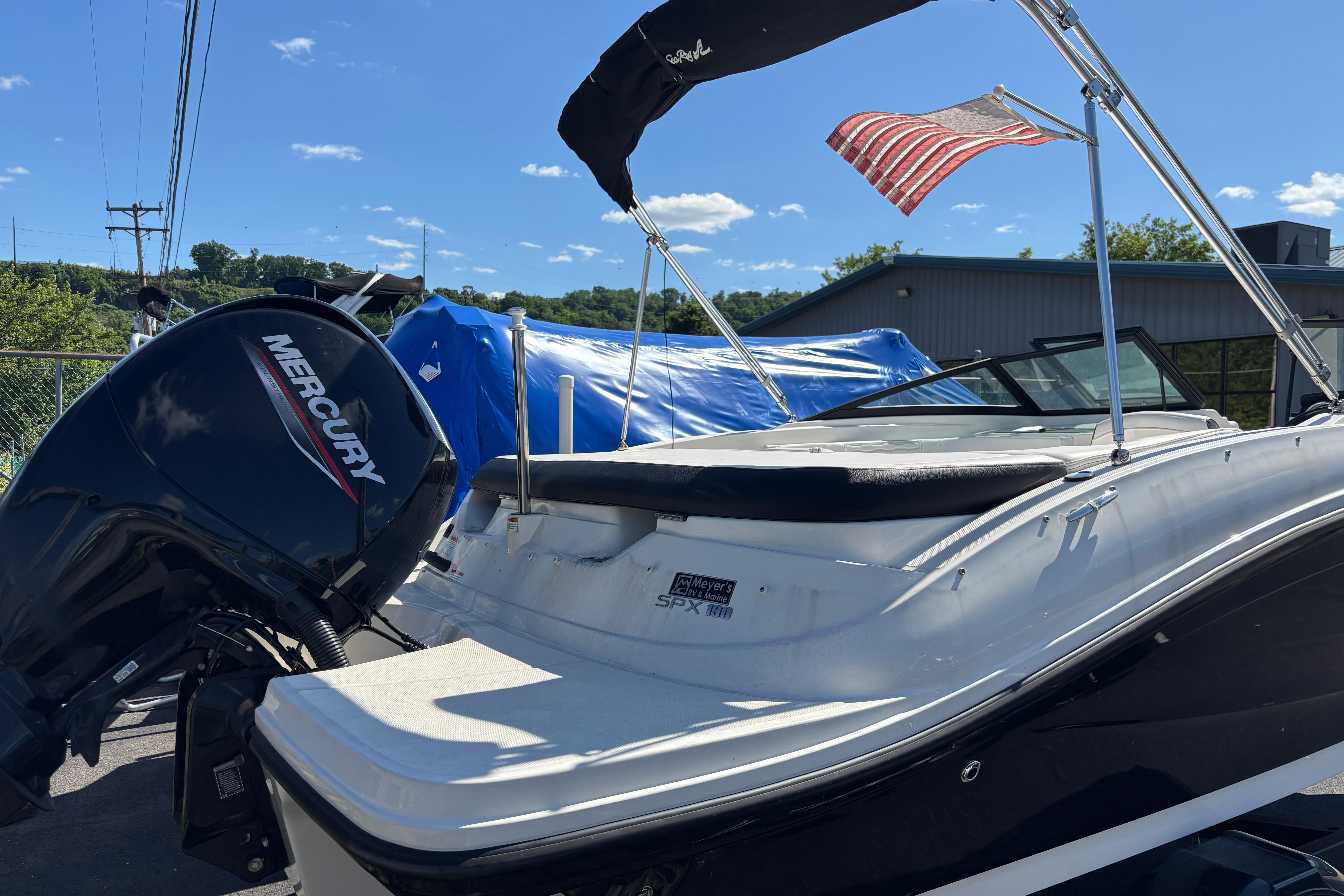 2022 Sea Ray SPX 190 Outboard boat with Mercury engine, docked under clear blue sky.