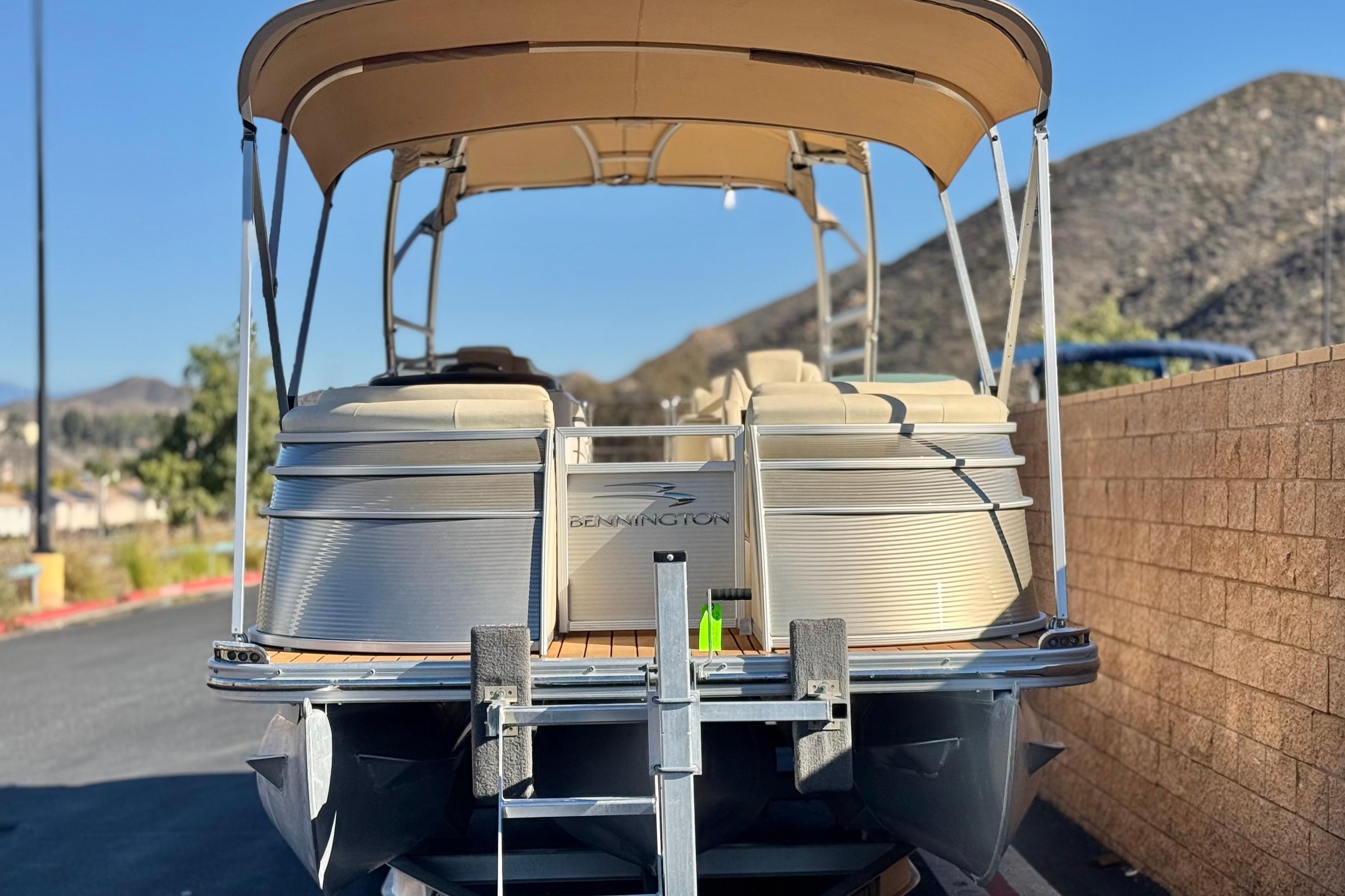 2013 Bennington 2575QCW I/O pontoon boat on trailer, beige canopy, outdoor setting.