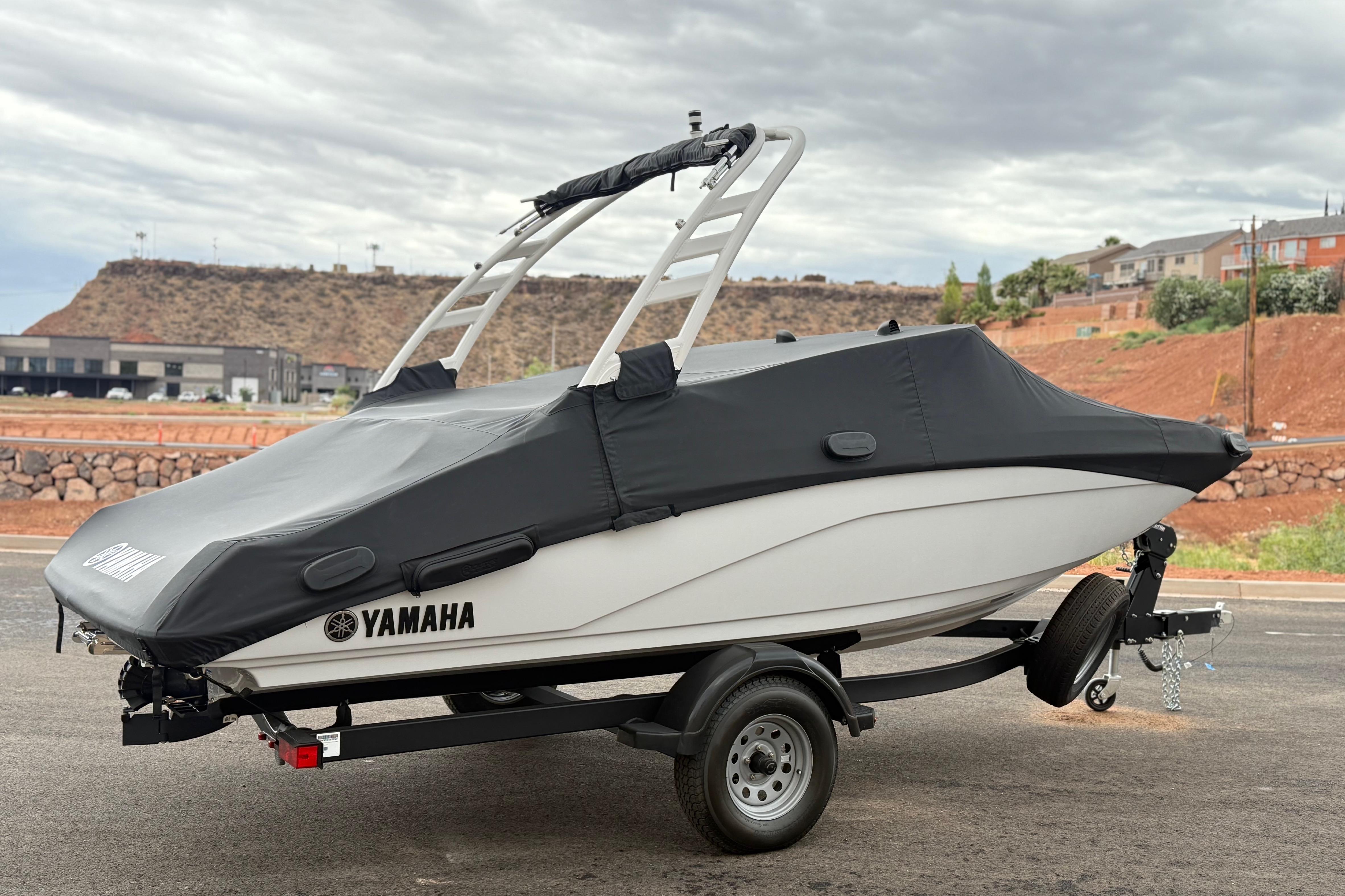 2025 Yamaha Boats 195S covered on trailer, parked outdoors with scenic background.