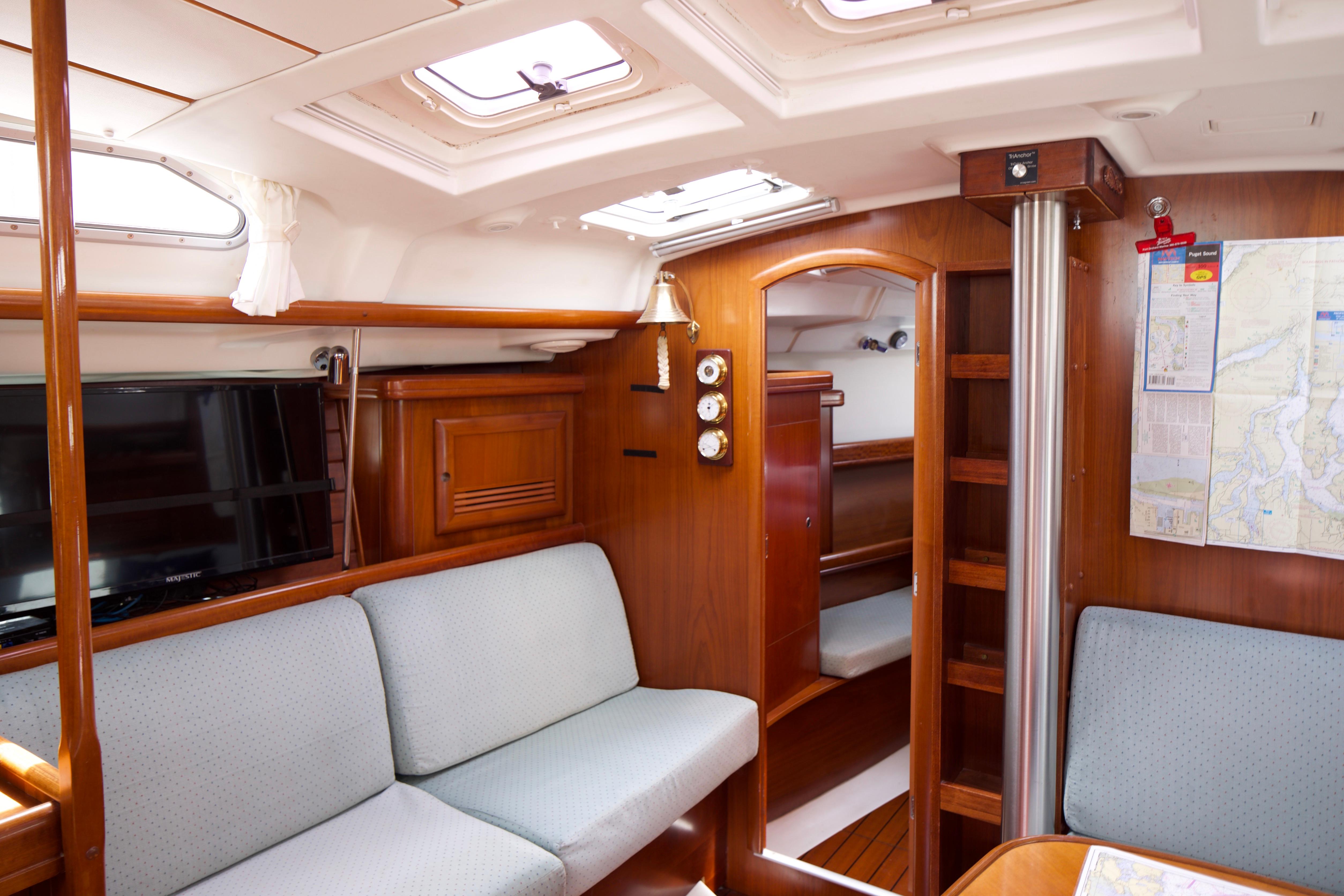 Interior of a 2005 Beneteau 423 sailboat with cozy seating and navigation equipment.