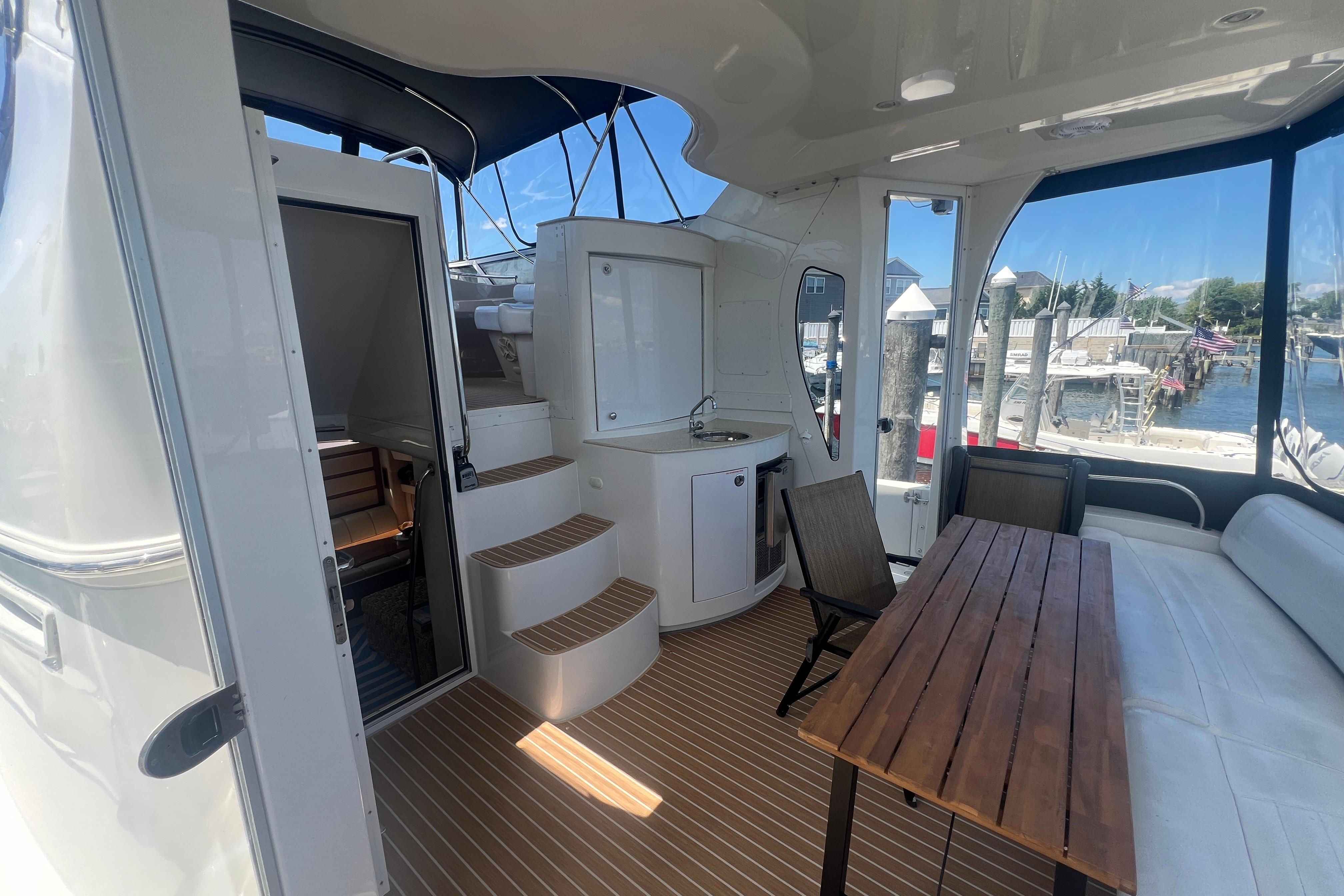 2006 Carver 43 Motor Yacht interior with seating, table, and marina view.