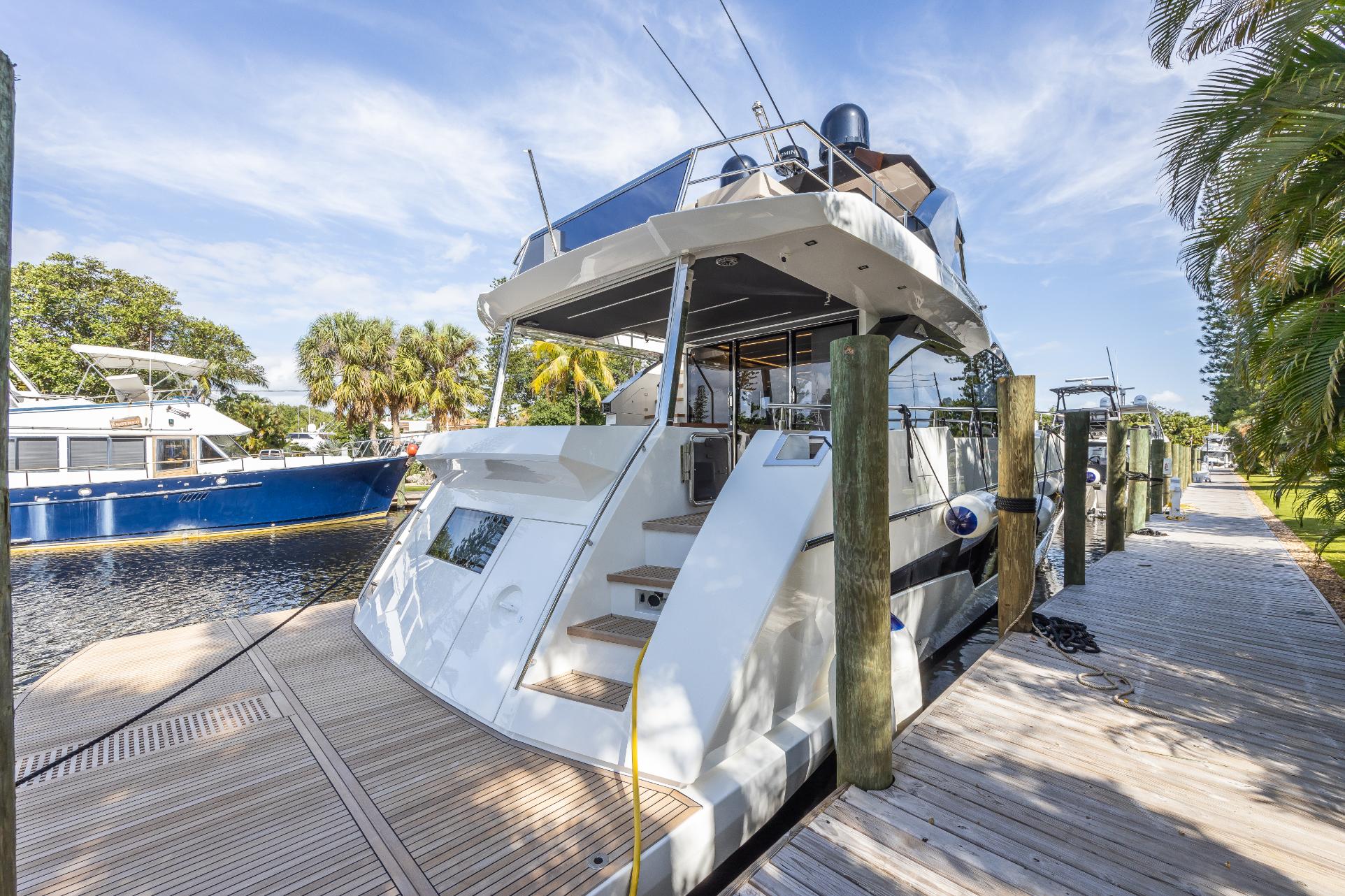 2024 Astondoa 66 Flybridge yacht docked at a marina on a sunny day.