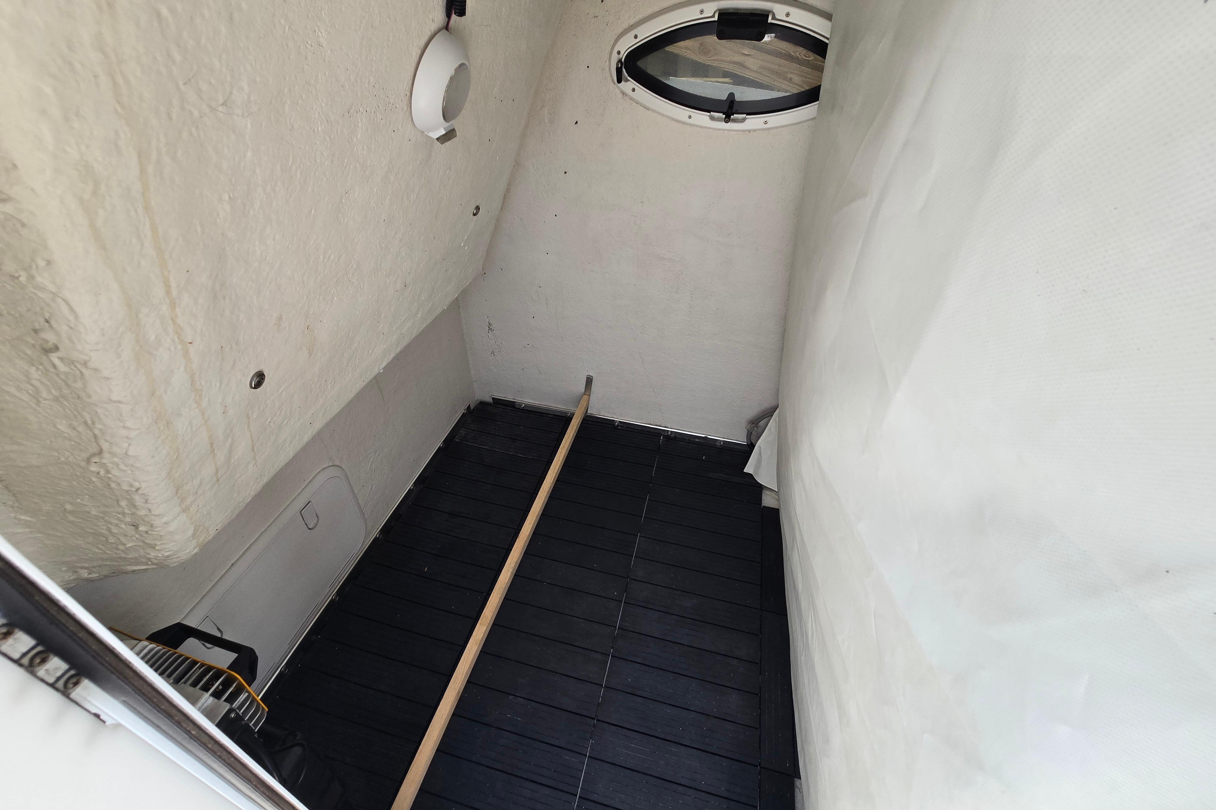 Interior cabin of 2021 Twin Vee 280 GFX CC boat, featuring a small window and minimalistic design.