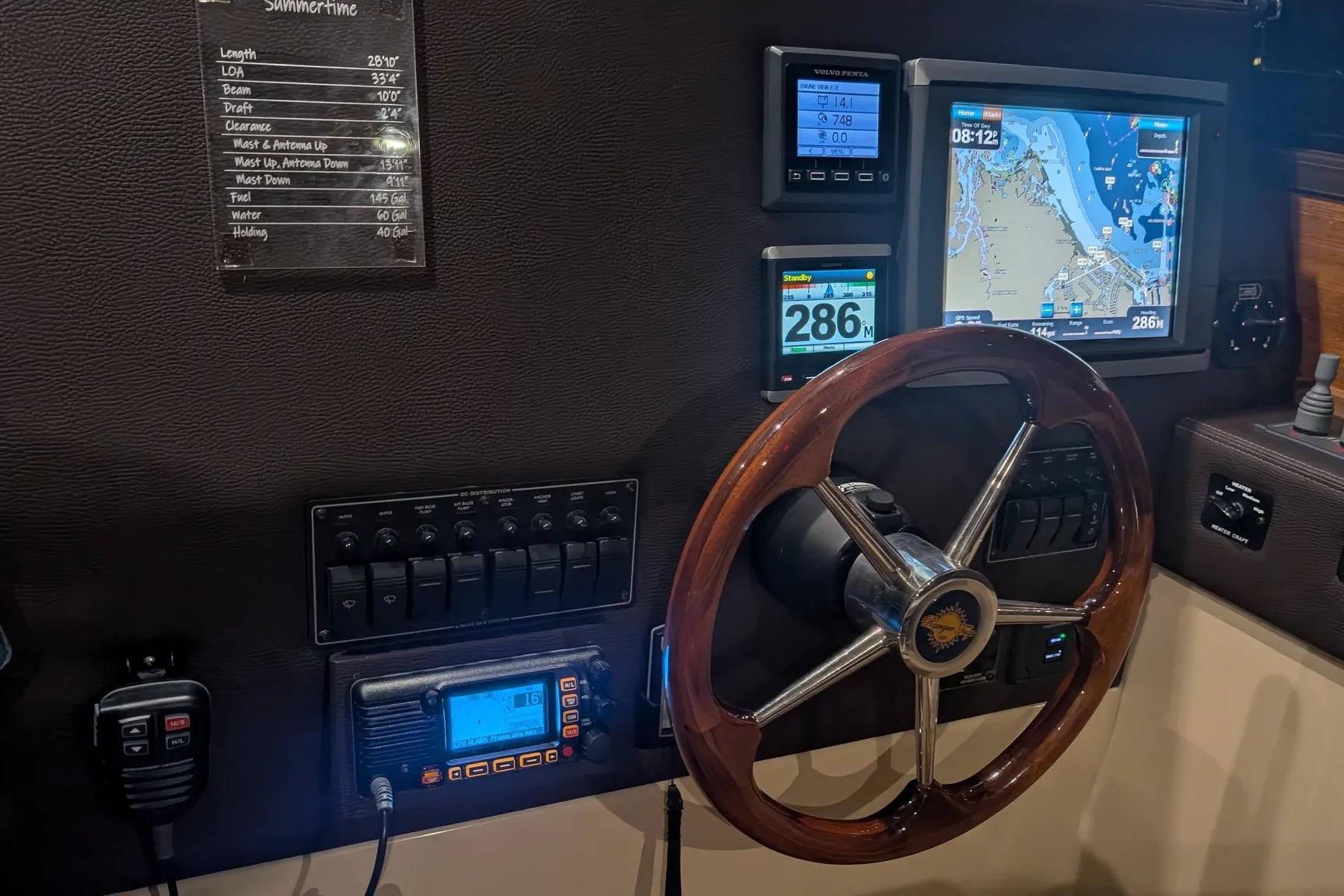 2015 Ranger Tugs R-29 S helm with navigation screens and wooden steering wheel.