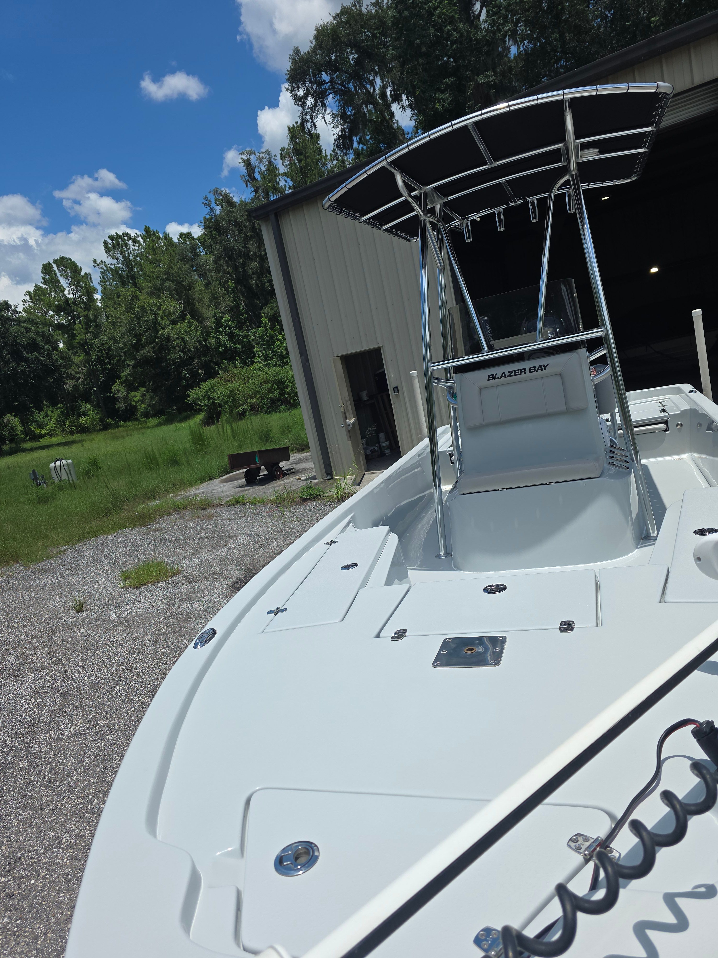 A 2019 Blazer Bay 2200 boat is parked outside a warehouse on a gravel lot.