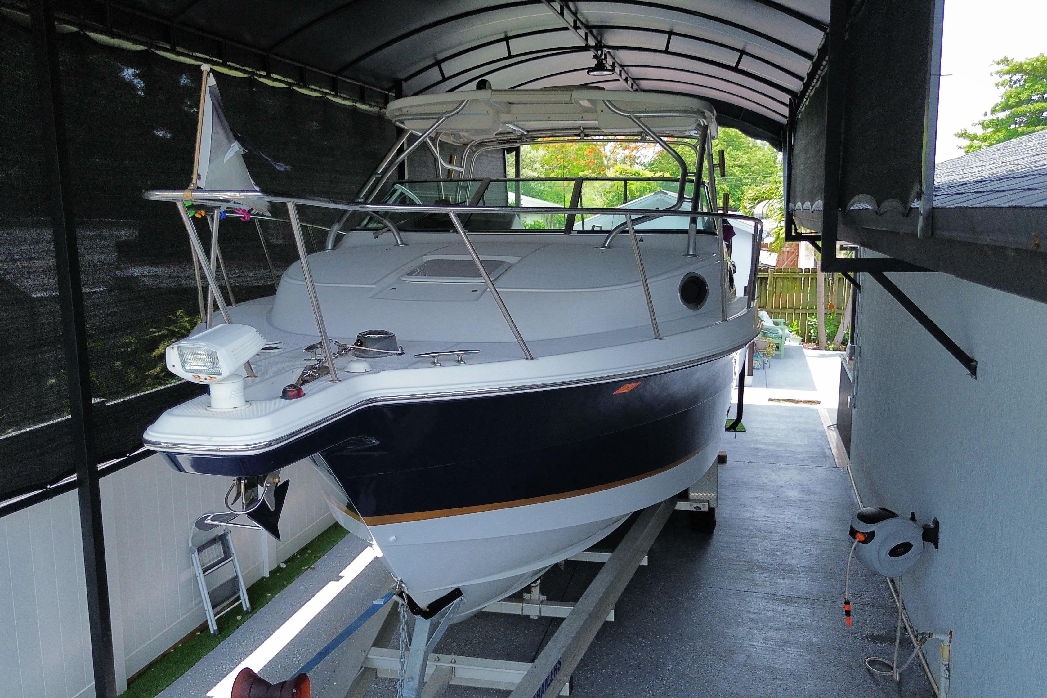2005 Wellcraft 290 Coastal boat on trailer under covered storage.