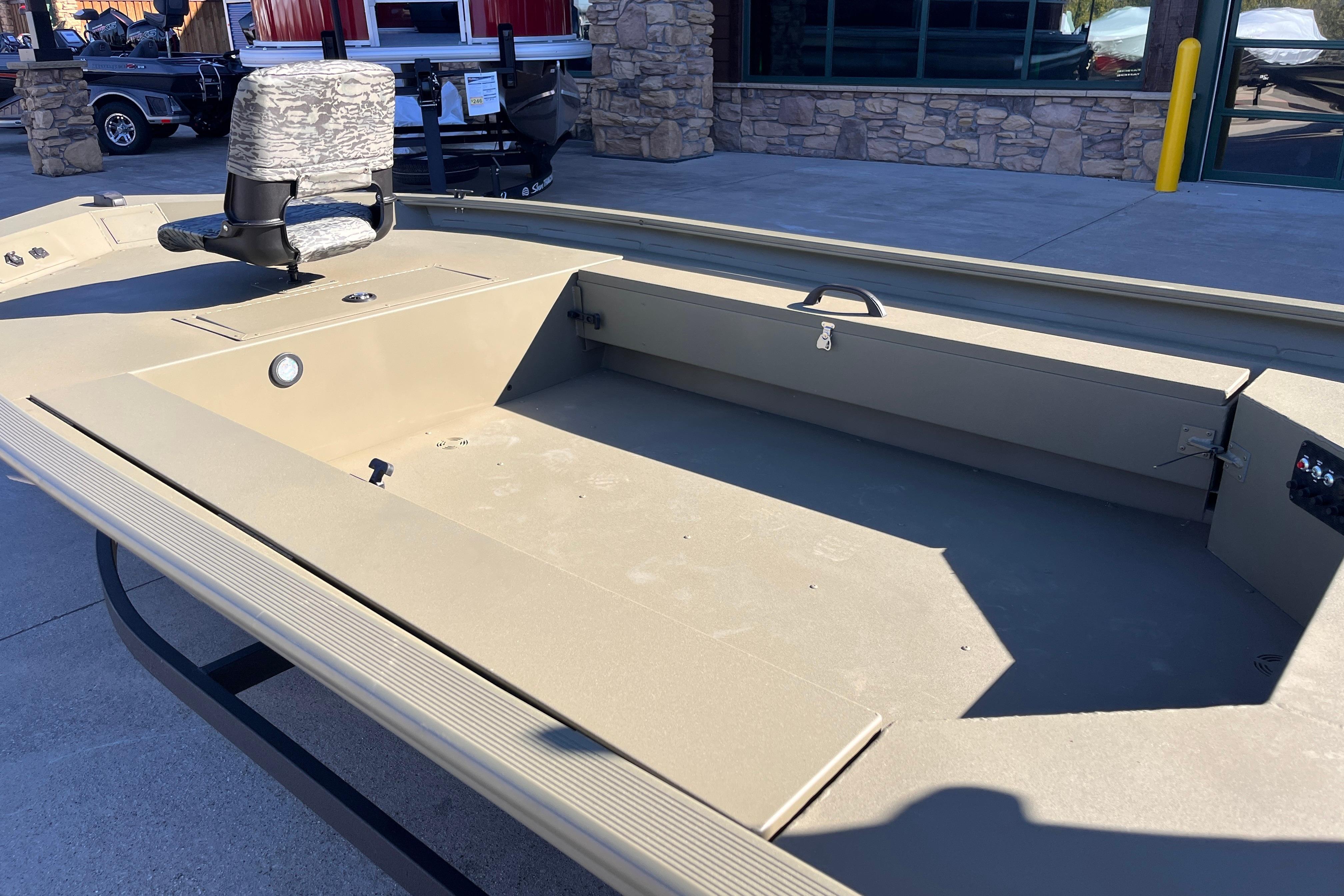 2026 Tracker Grizzly 1654 T Sportsman boat with camouflage seat, displayed outdoors.