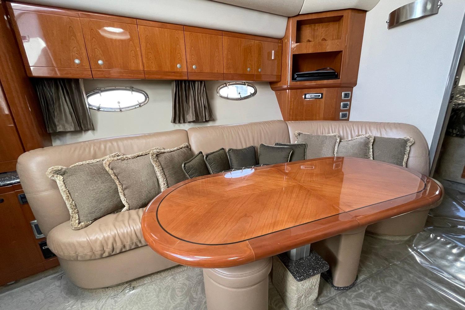Luxurious interior of 2005 Formula 48 Yacht with plush seating and elegant wooden table.