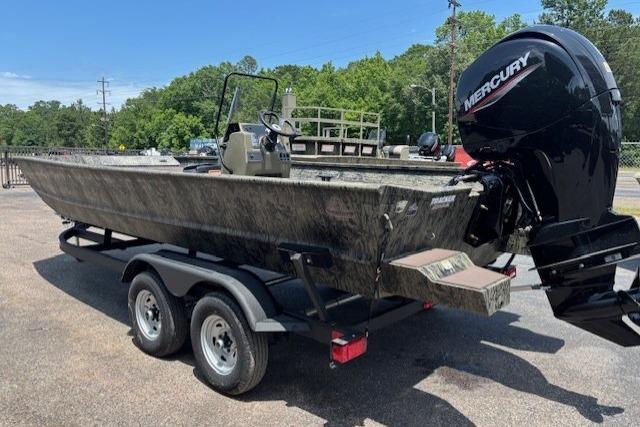 2026 Tracker Grizzly 2072 CC boat with Mercury engine on a trailer, parked outdoors.