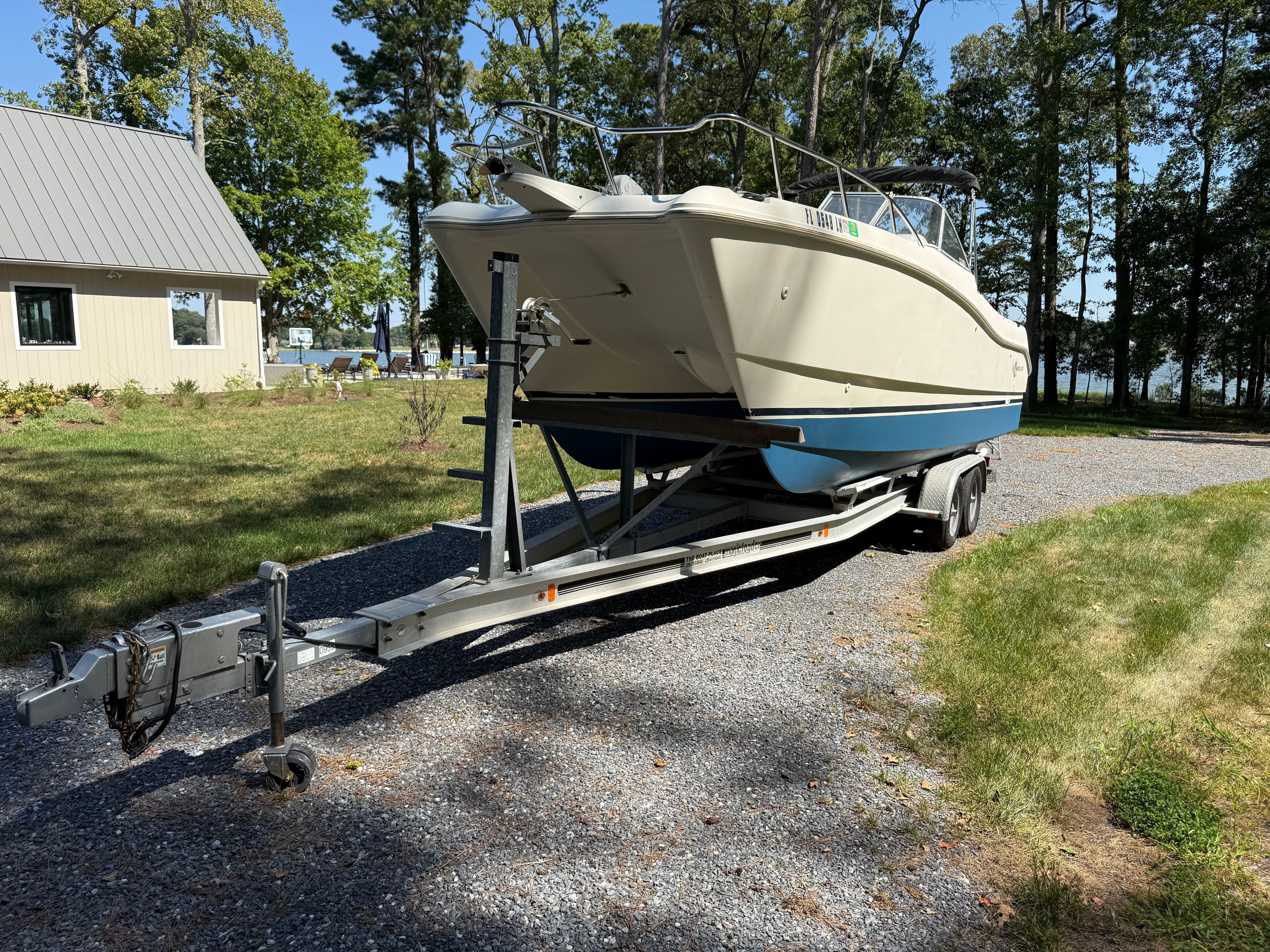2002 World Cat 246 DC boat on trailer parked outdoors.