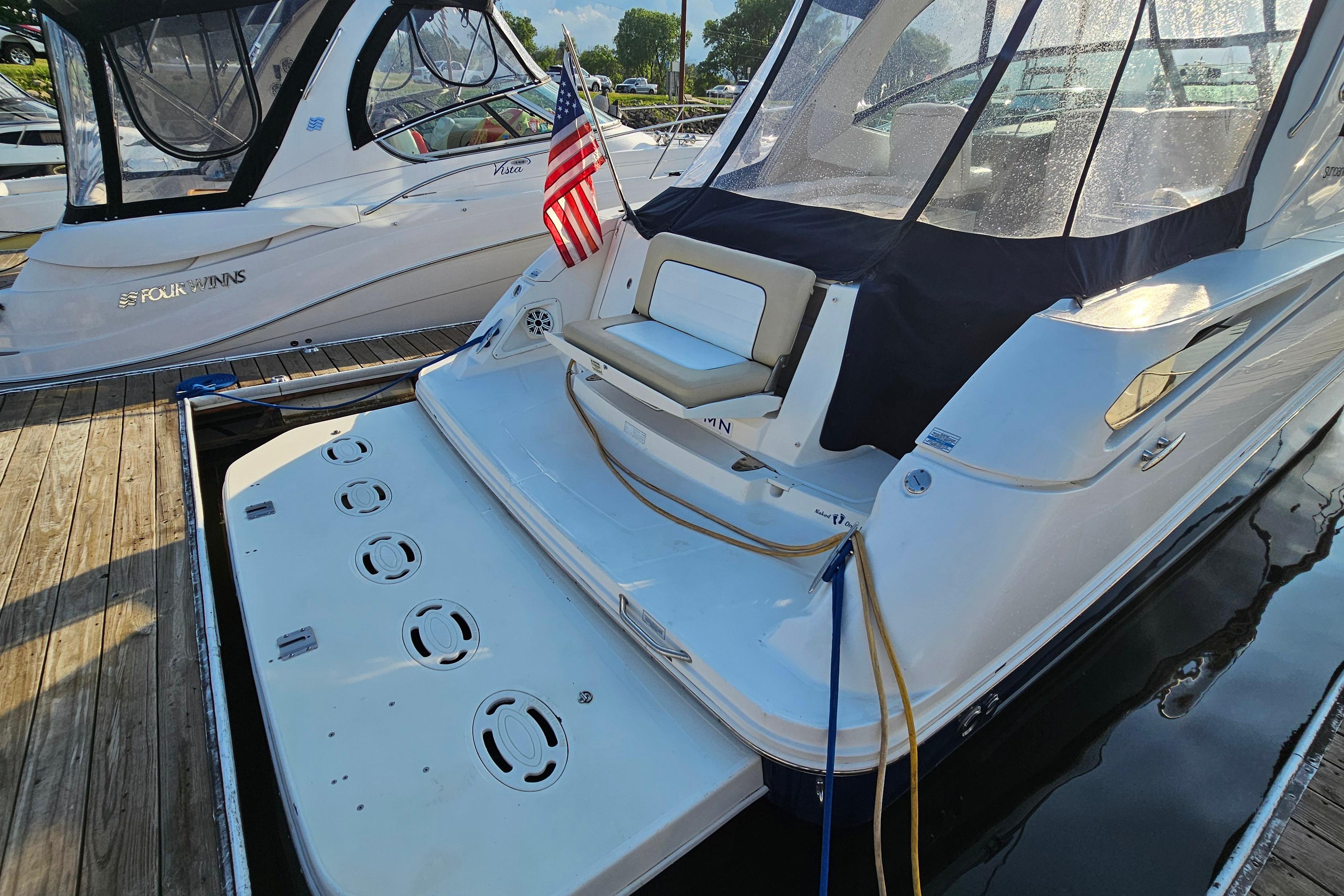 2008 Sea Ray Sundancer 350 docked, featuring a spacious swim platform and American flag.